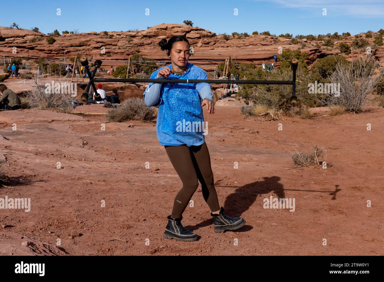 A young woman practices with a fire dragon staff at the GGBY Highlining Festival in Moab,  Utah.  She is rolling the staff down her arm.  Usually perf Stock Photo