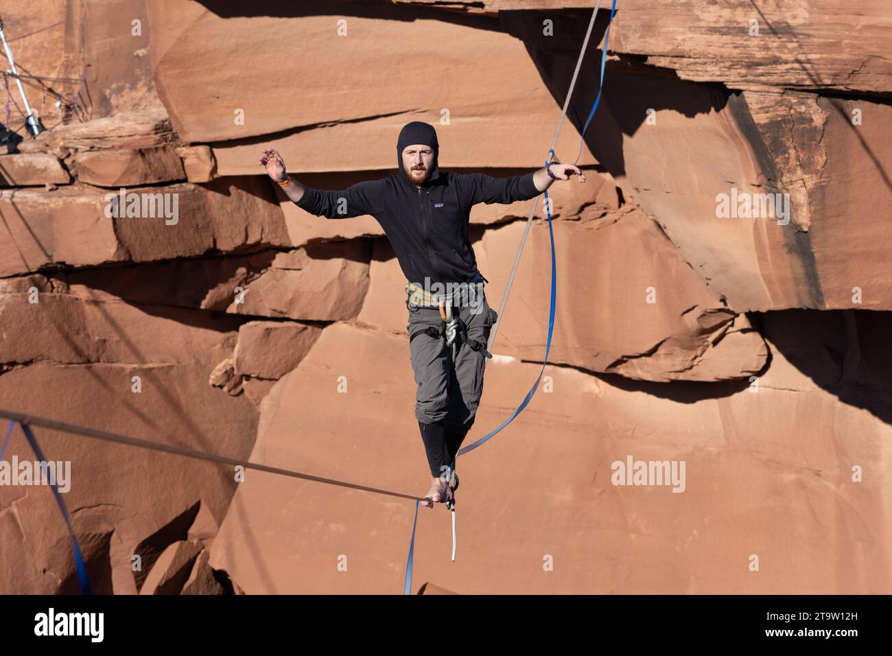 A man walking a highline at the GGBY World Highline Festival in Mineral Canyon near Moab, Utah. Stock Photo