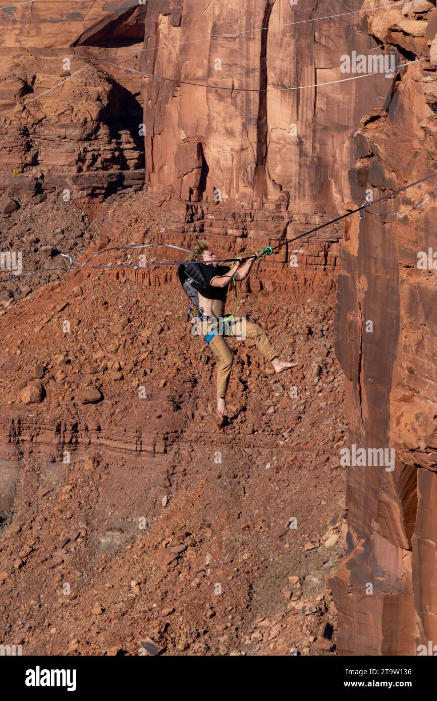 A male highliner grabs the line after whipping, or falling off the
