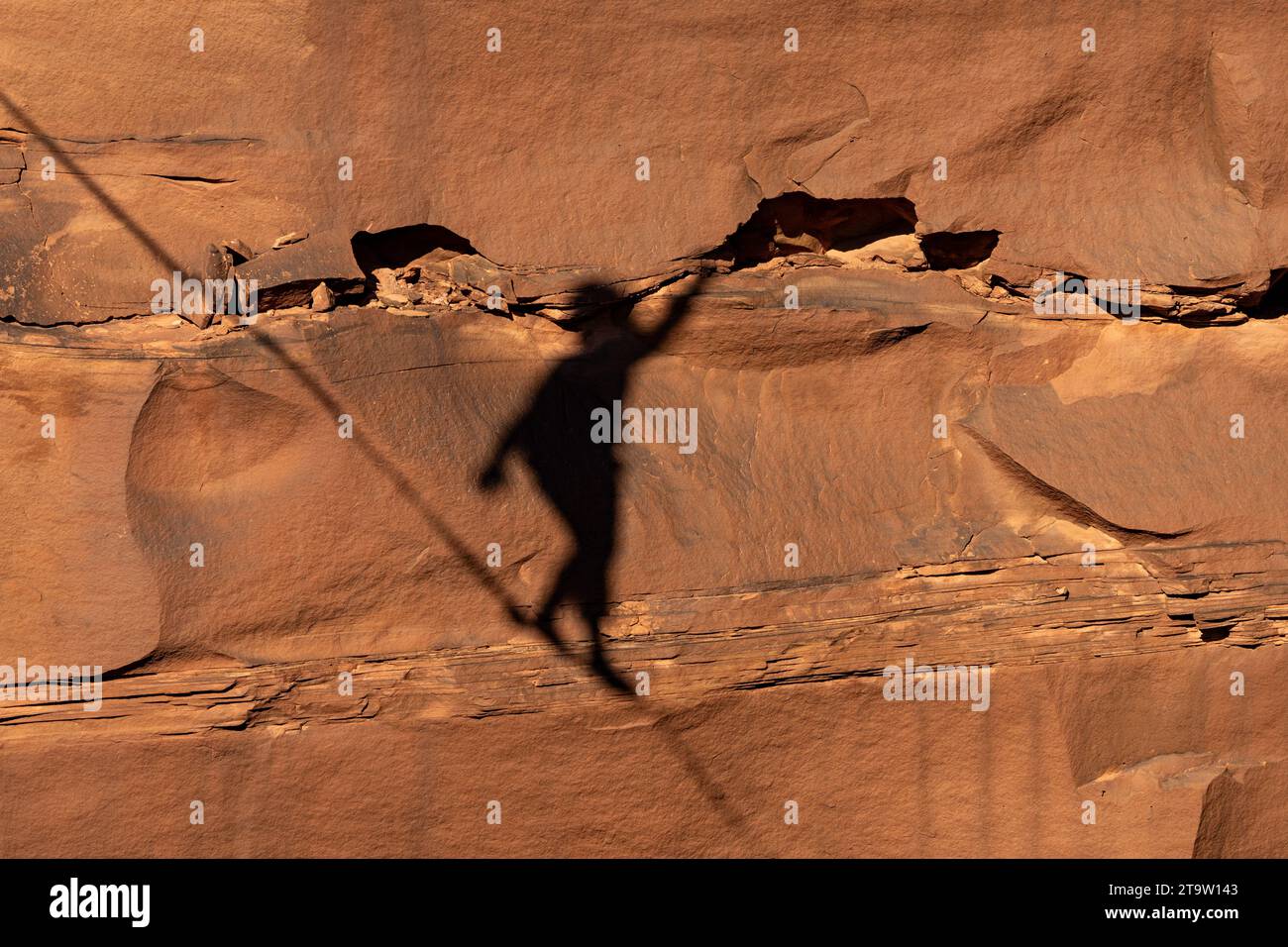 Shadow of a highliner on the canyon wall 500 feet above the canyon floor at a highline festival in Utah. Stock Photo