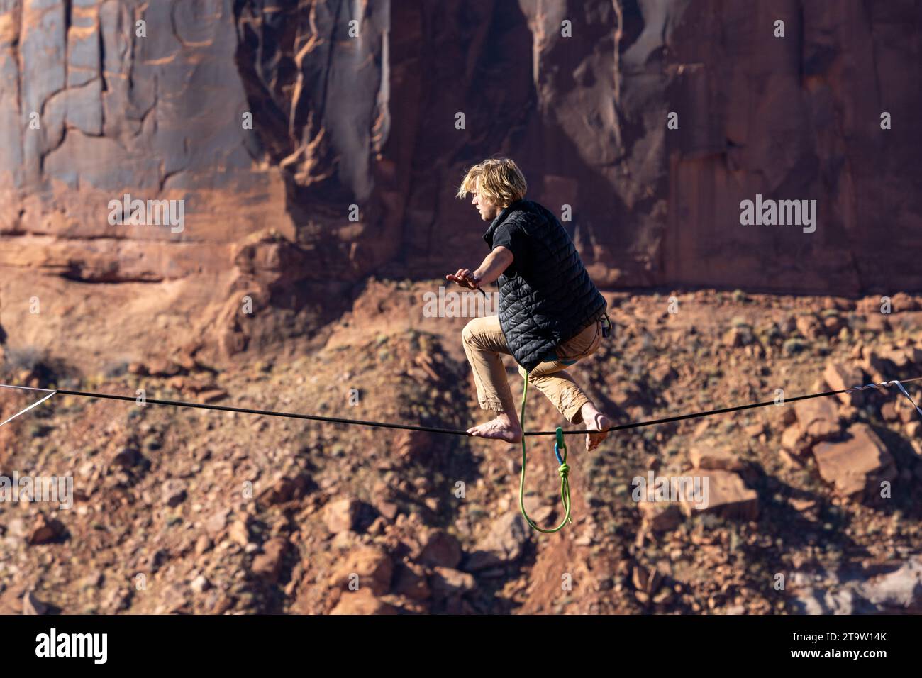 A man walking a highline at the GGBY World Highline Festival in Mineral Canyon near Moab, Utah. Stock Photo