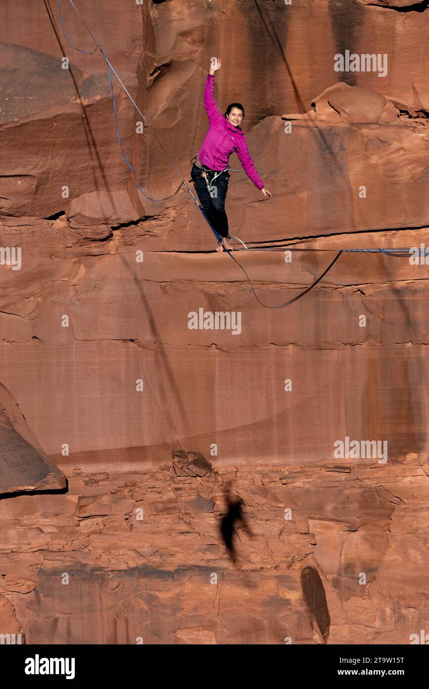 A woman on the highline with her shadow over Mineral Canyon at the GGBY World Highline Festival near Moab, Utah. Stock Photo