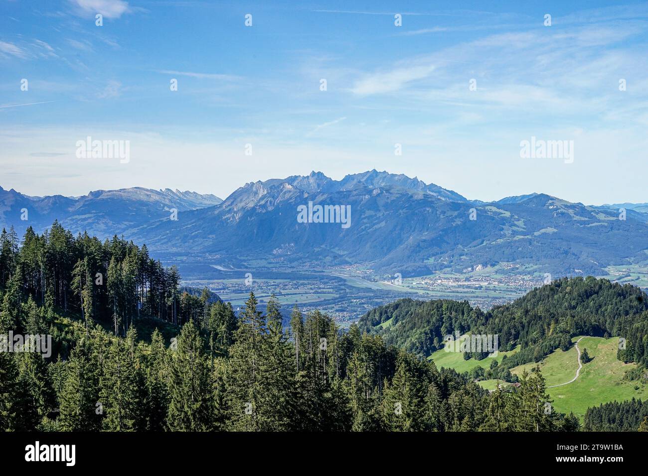 Towering peaks stretch across the horizon and their rugged outlines softened by a gentle haze. Stock Photo