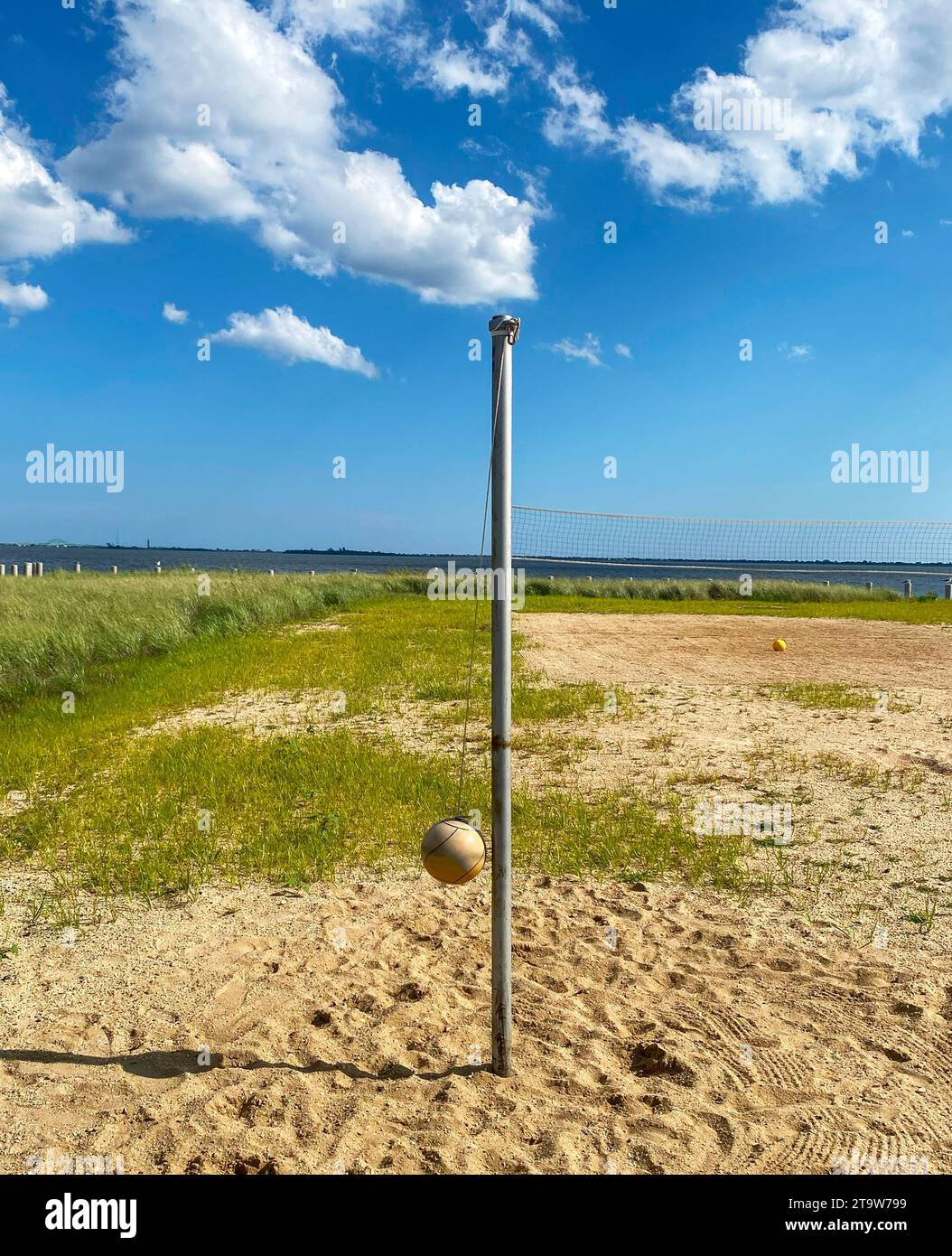 Beach tetherball spole and ball et up in the sand overlooking the bay. Stock Photo