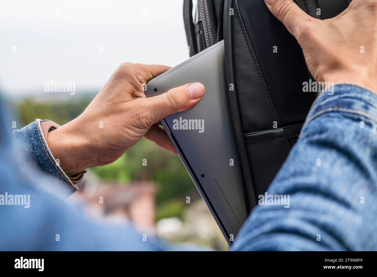 Woman packing a laptop in backpack for a trip Stock Photo
