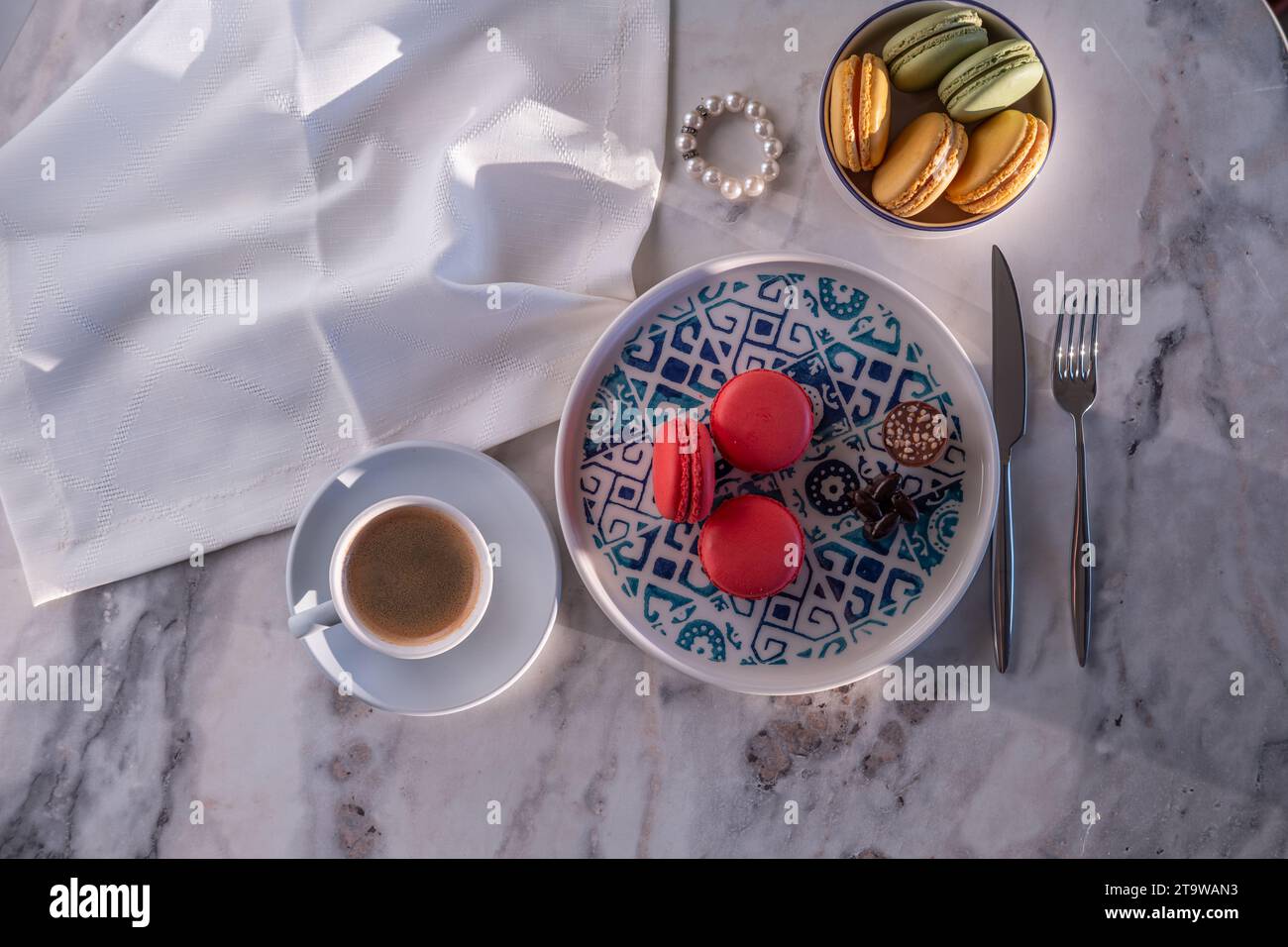 Colorful macarons and filter coffee on a blue plate Stock Photo