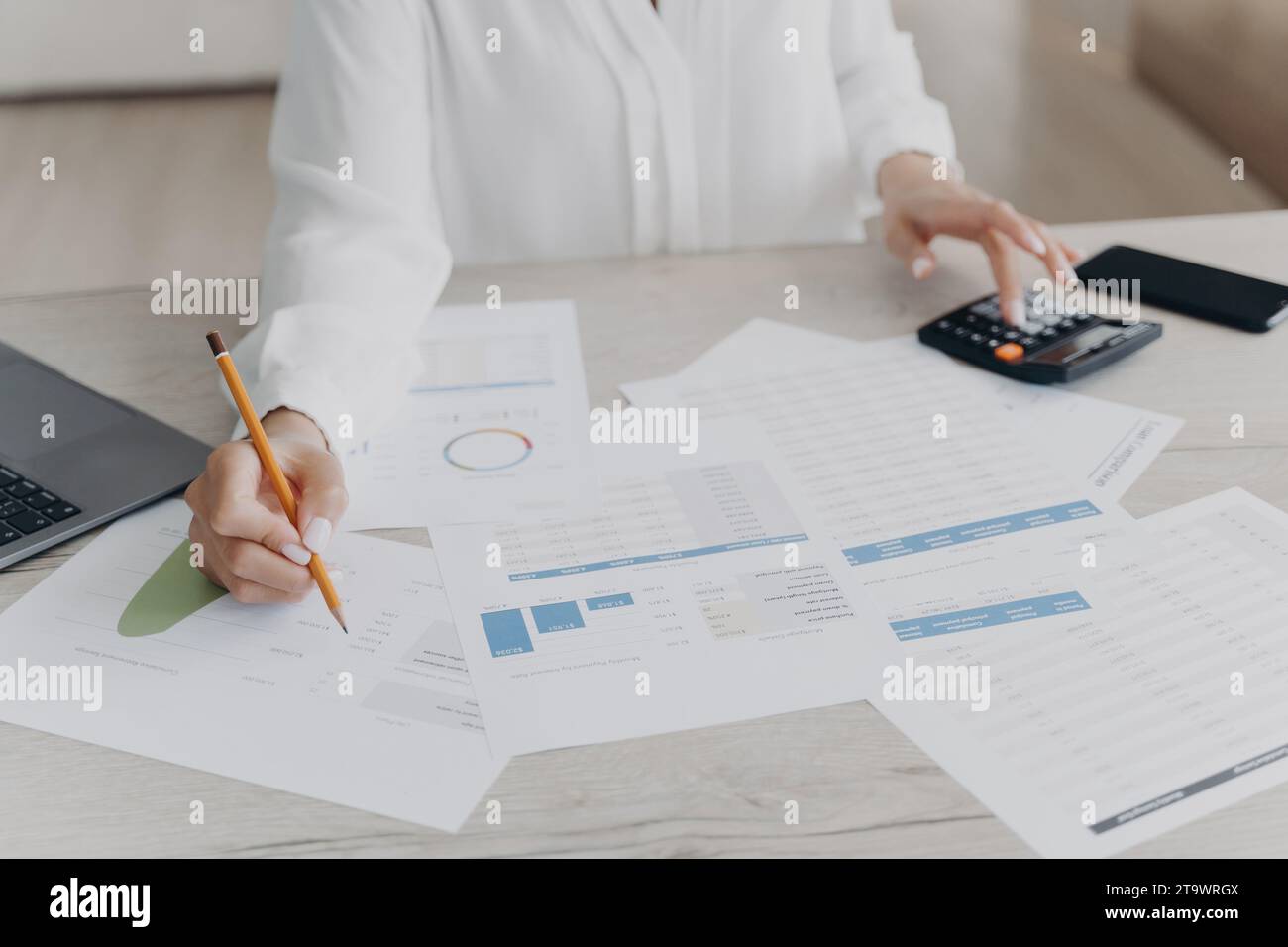 Professional at work analyzing financial data with calculator and documents Stock Photo