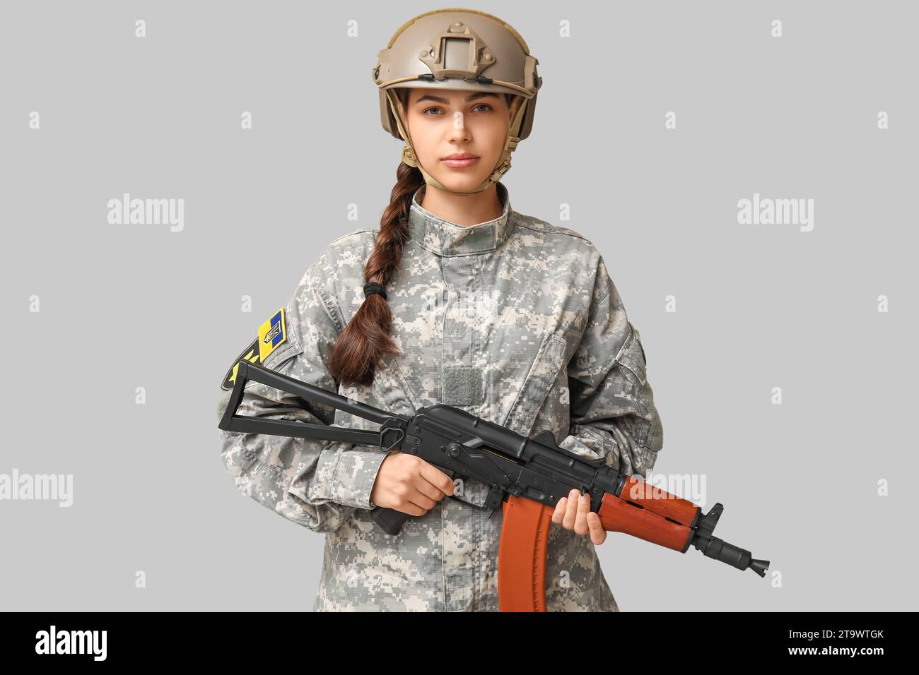 Confident female soldier in uniform with Ukrainian flag patch on sleeve ...