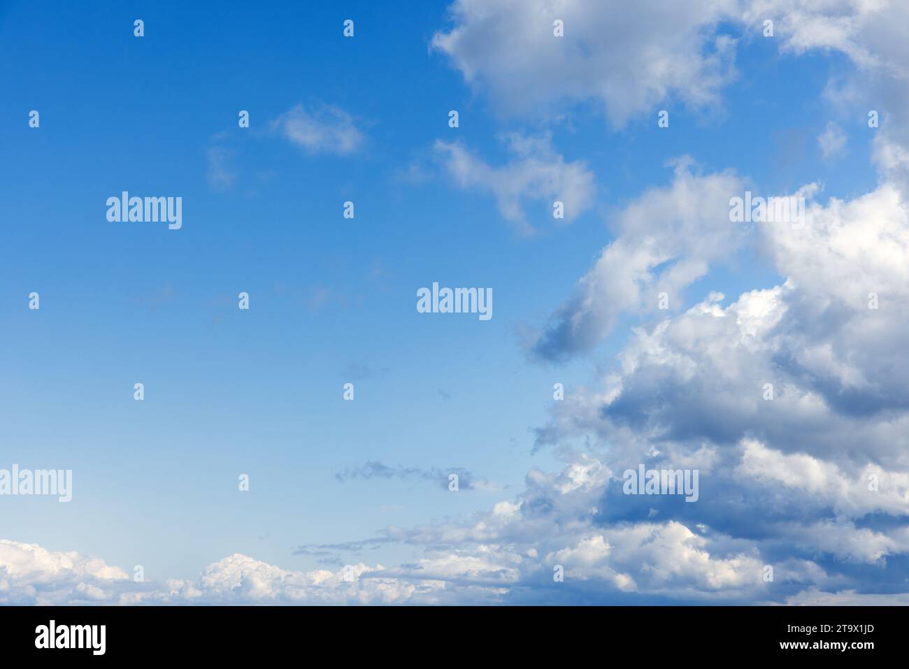Blue sky with white cumulus clouds formation on a sunny day. Natural ...