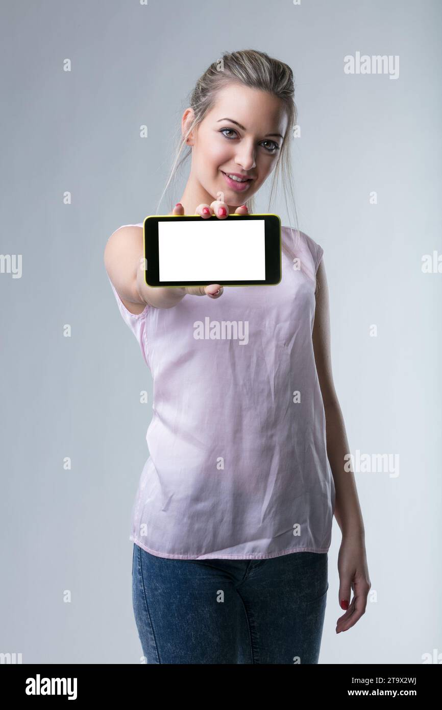 Tech-savvy woman offers a digital device, inviting technological engagement Stock Photo