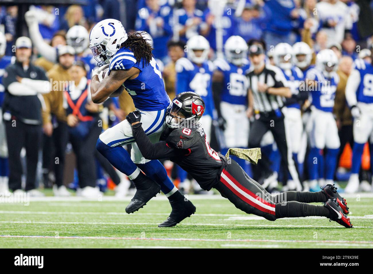 Indianapolis, Indiana, USA. 26th Nov, 2023. Indianapolis Colts tight end Mo Alie-Cox (81) runs with the ball after the catch as Tampa Bay Buccaneers linebacker SirVocea Dennis (8) defends during NFL football game action at Lucas Oil Stadium in Indianapolis, Indiana. Indianapolis defeated Tampa Bay 27-20. John Mersits/CSM/Alamy Live News Stock Photo