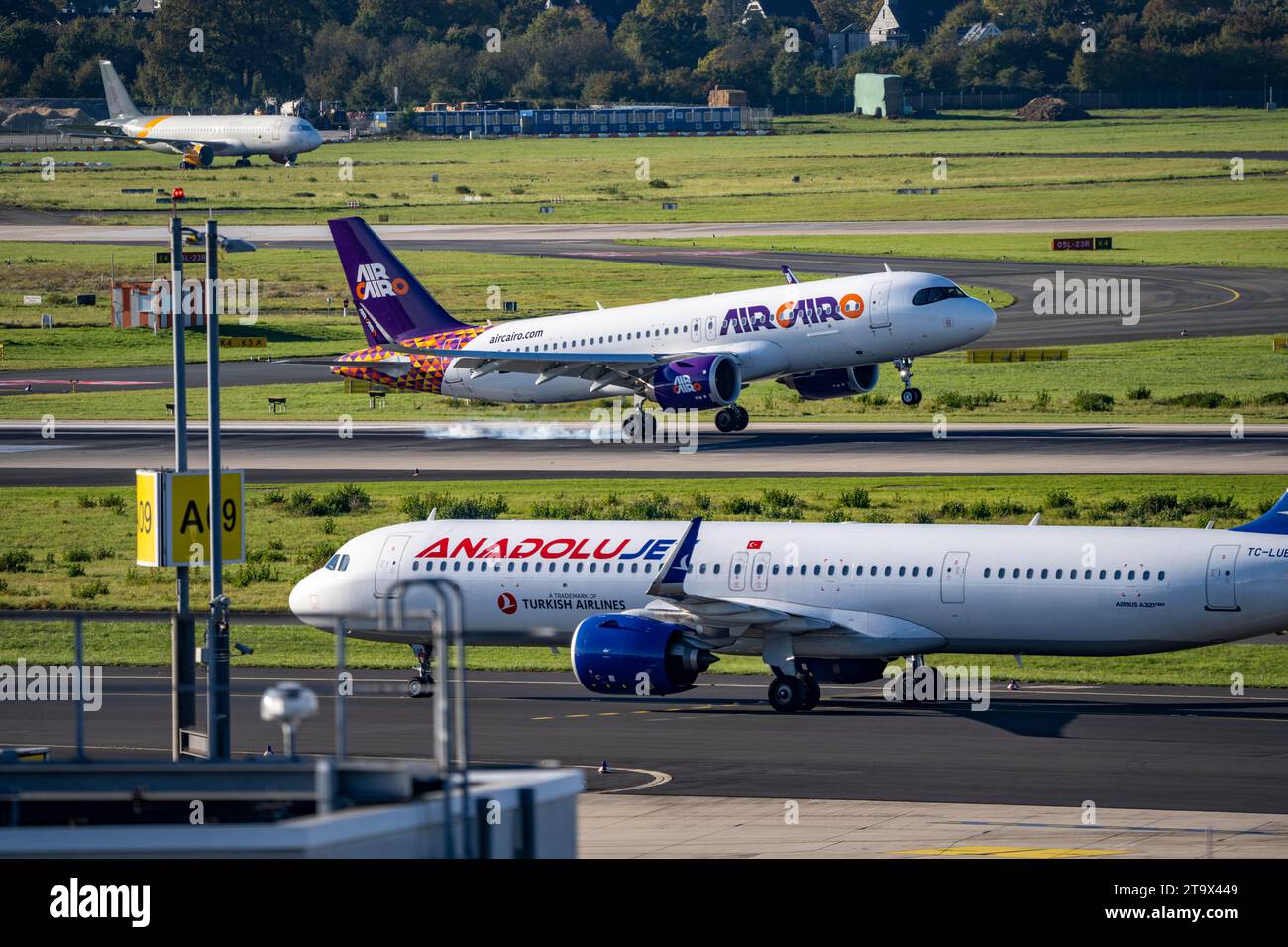 Düsseldorf Airport, Air Cairo Airbus A320neo on take-off, Anadolujet on the taxiway, Stock Photo