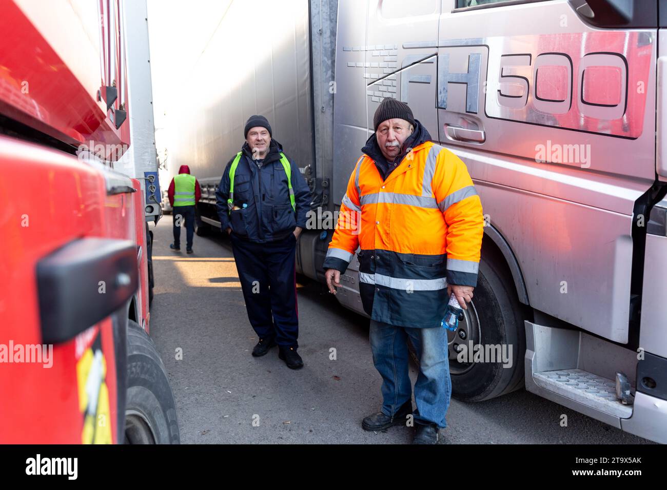 Ukrainian truck drivers stand by their trucks as they wait in a queue