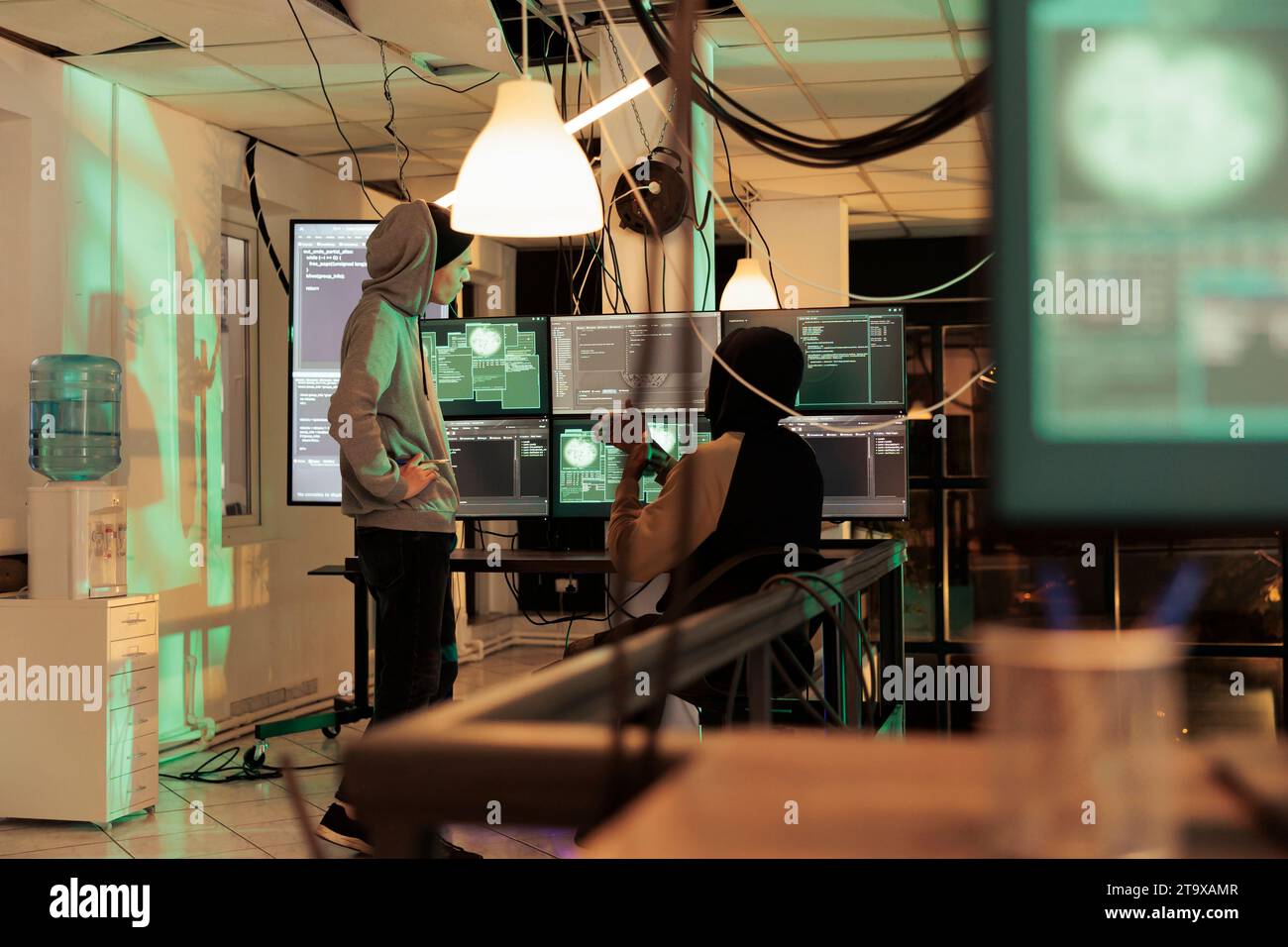 Hackers discussing spyware code, cracking online server password, getting illegal access. Cybertcrime, internet thieves hacking government computer system, developing malware script Stock Photo