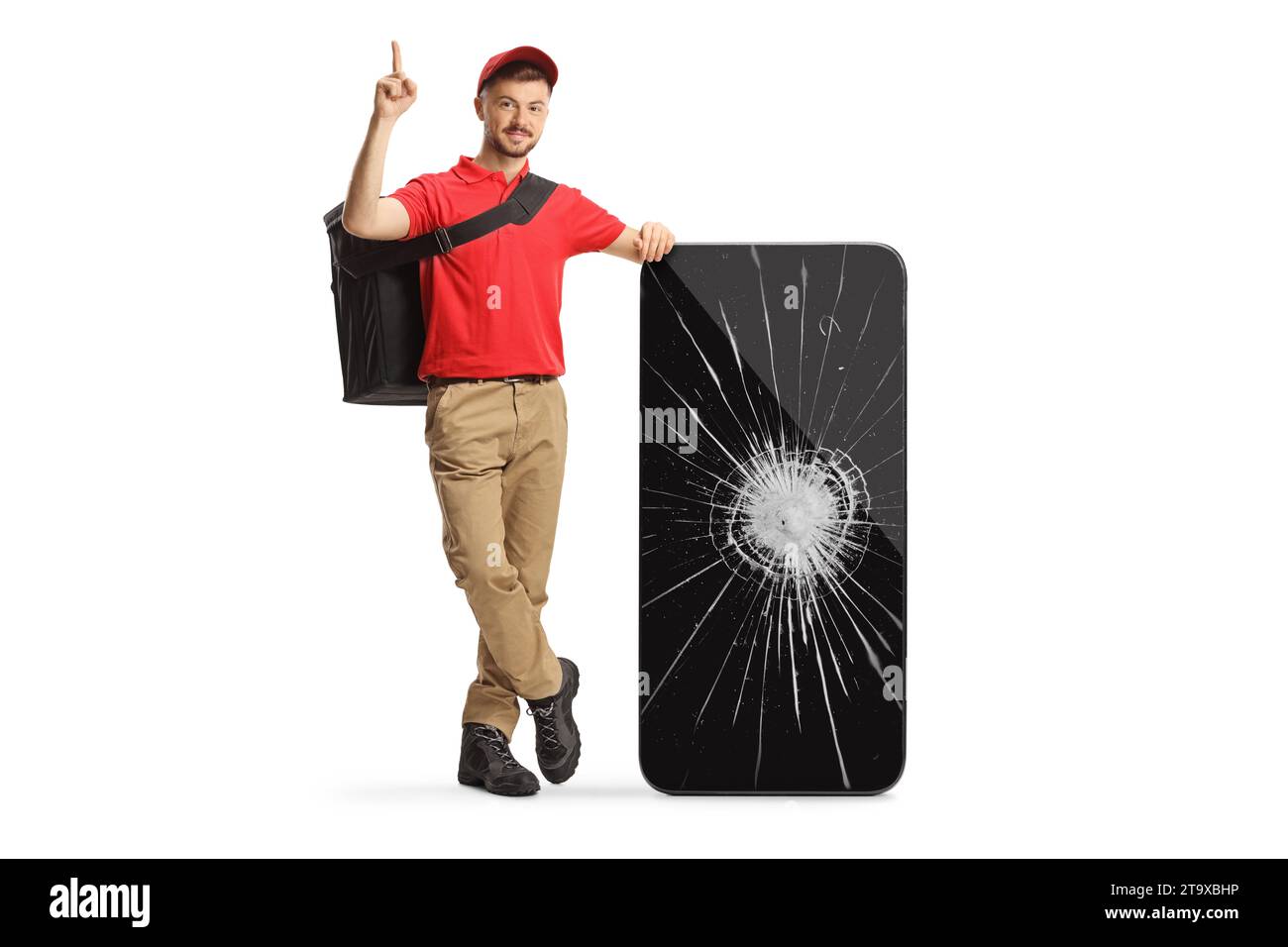 Delivery man leaning on a smartphone with a broken screen and pointing up isolated on white background Stock Photo