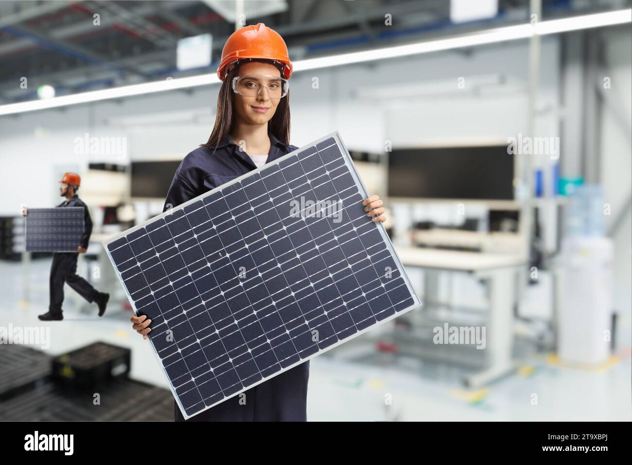 Solar panel production line, female worker in a factory holding a photovoltaic Stock Photo