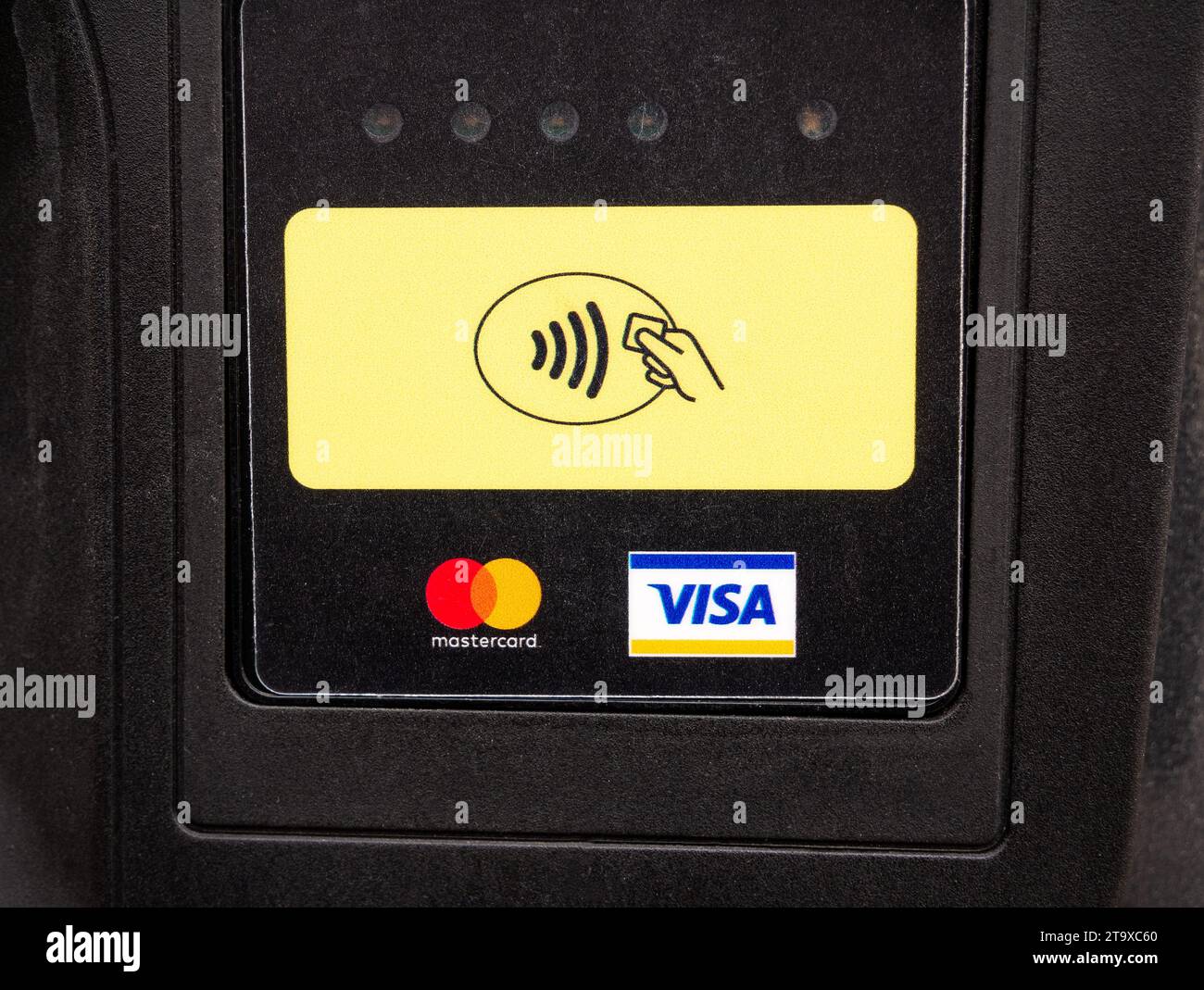 NFC card EMV contactless payment symbol on a payment terminal near MasterCard and Visa bank logos, object front view, closeup, nobody Cashless paying Stock Photo