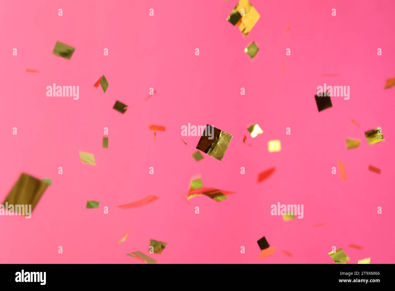 Shiny golden confetti falling down on pink background Stock Photo - Alamy