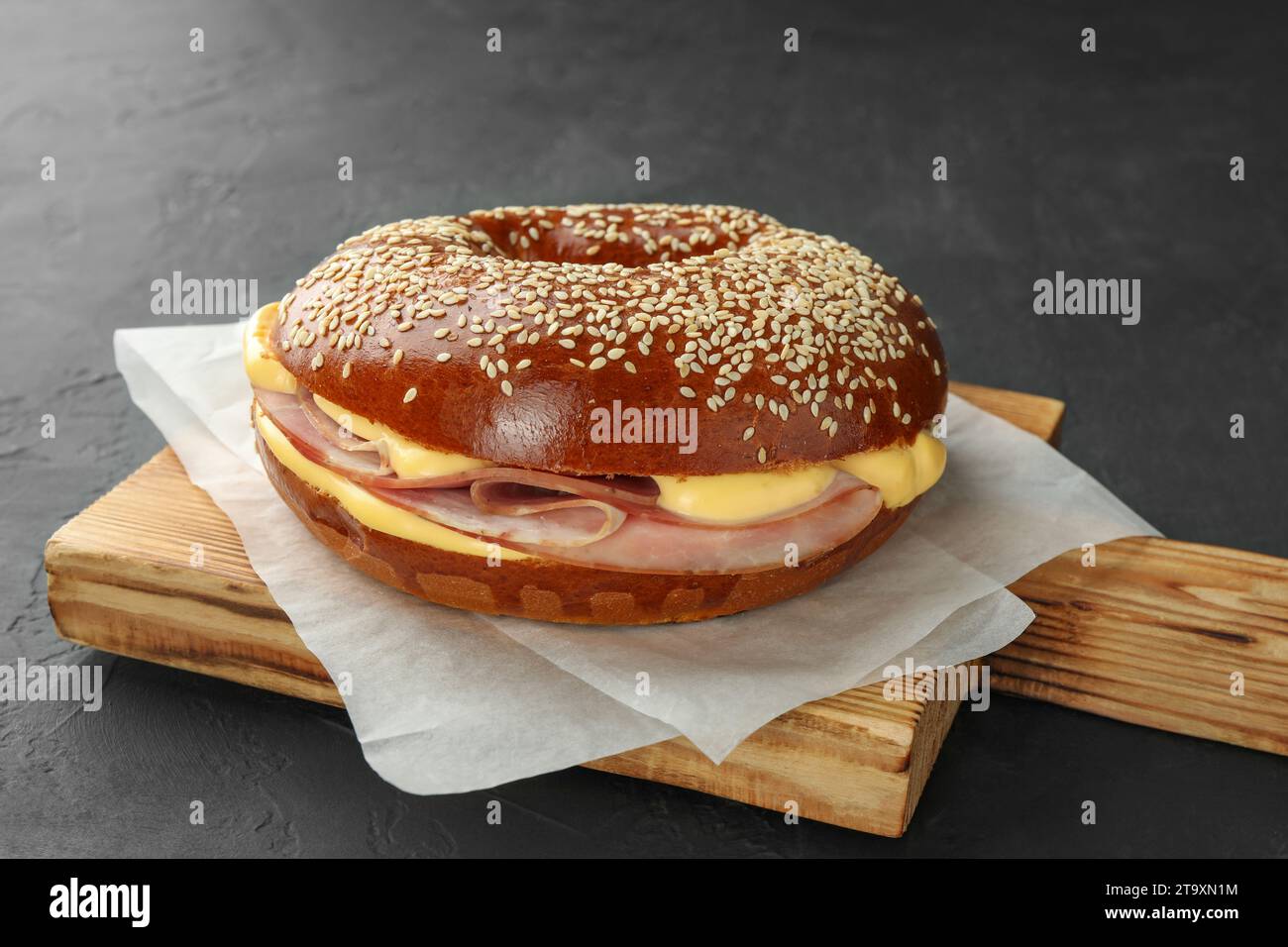 Delicious bagel with ham and cheese on grey table Stock Photo Alamy