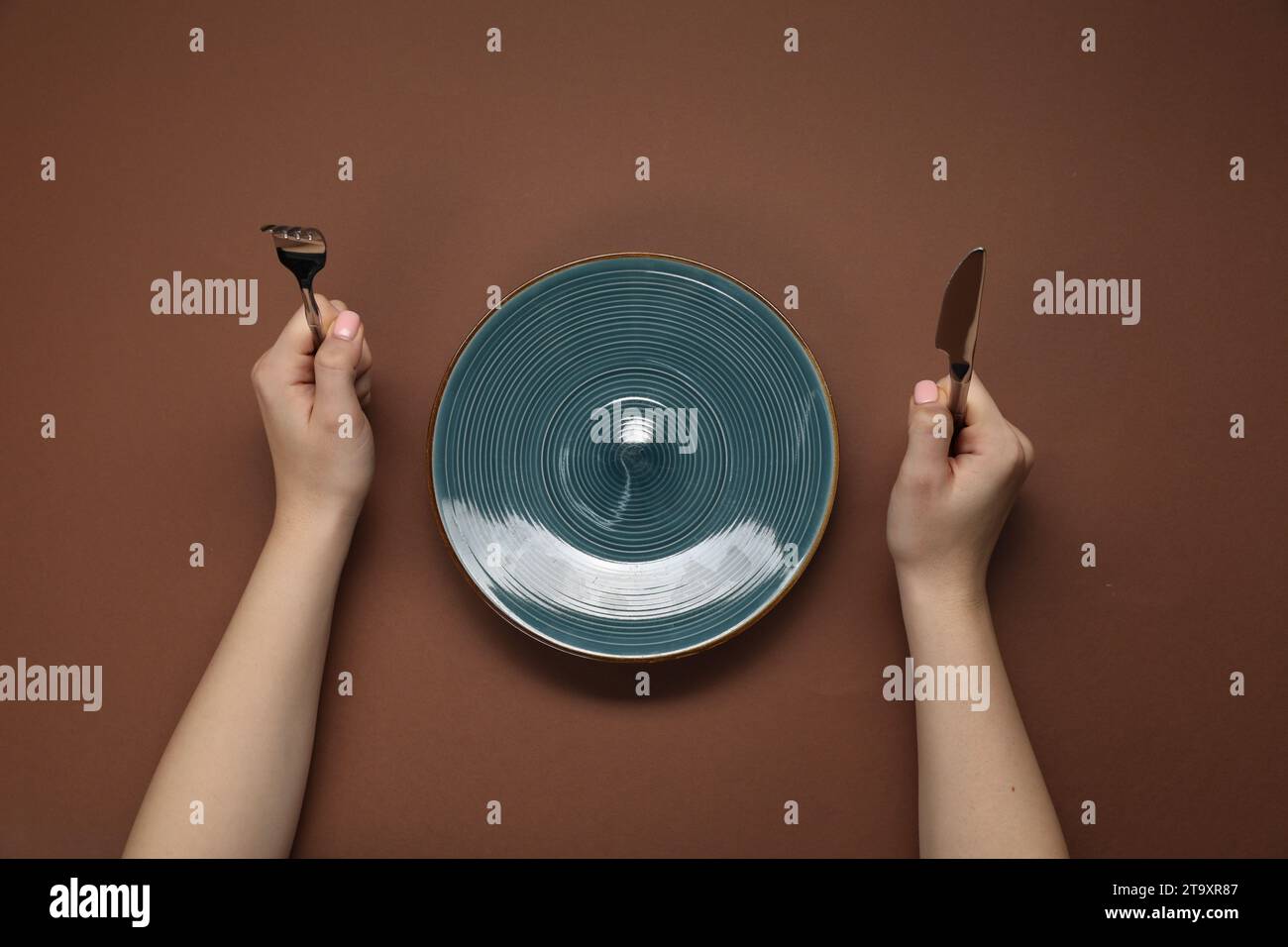 Brown hands holding fork knife hi-res stock photography and images - Alamy