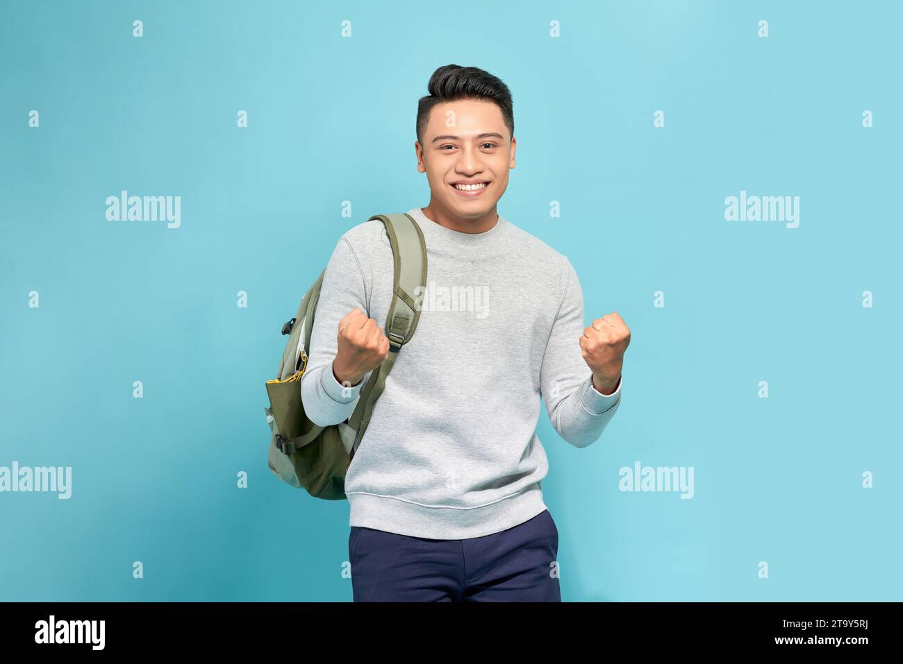 Portrait of happy excited young Asian tourist backpacker man raising ...