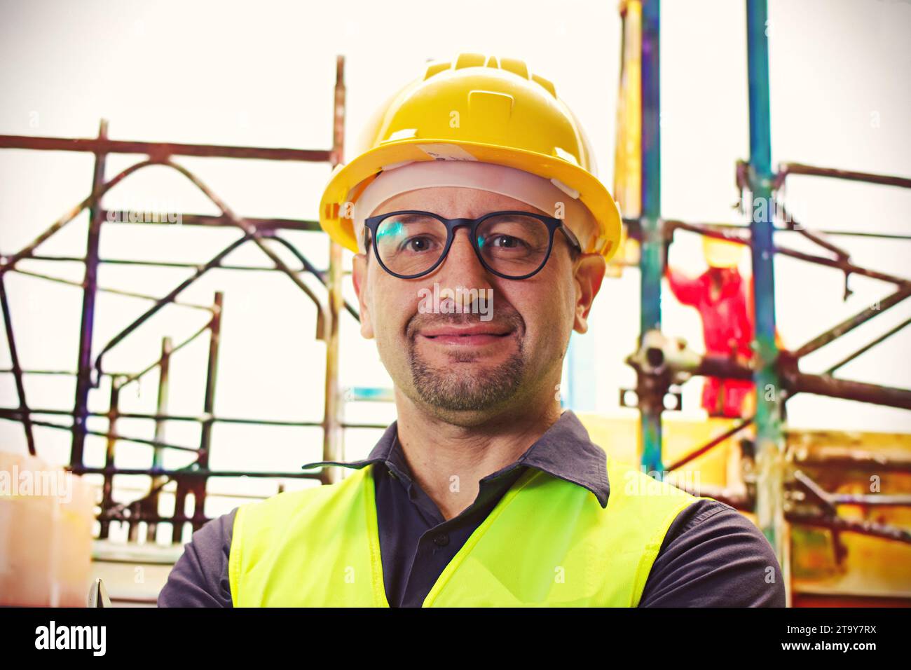 Construction, building and construction worker, man and smile in portrait, employee at construction site with work vest and safety helmet. Working, ar Stock Photo