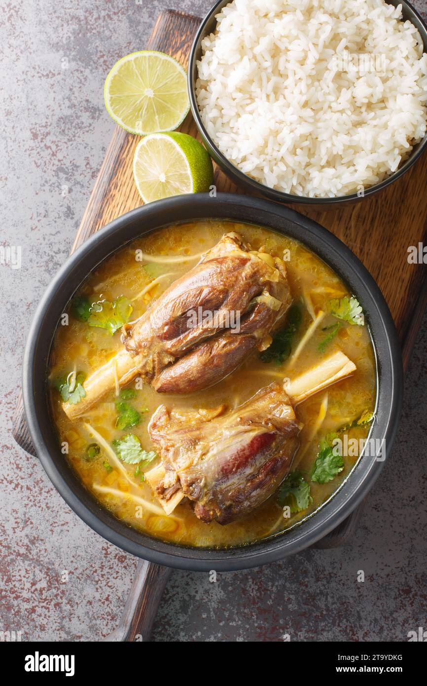 Nihari is a rich slow-cooked meat stew flavored with spices and thickened with atta closeup on the wooden board on the table. Vertical top view from a Stock Photo