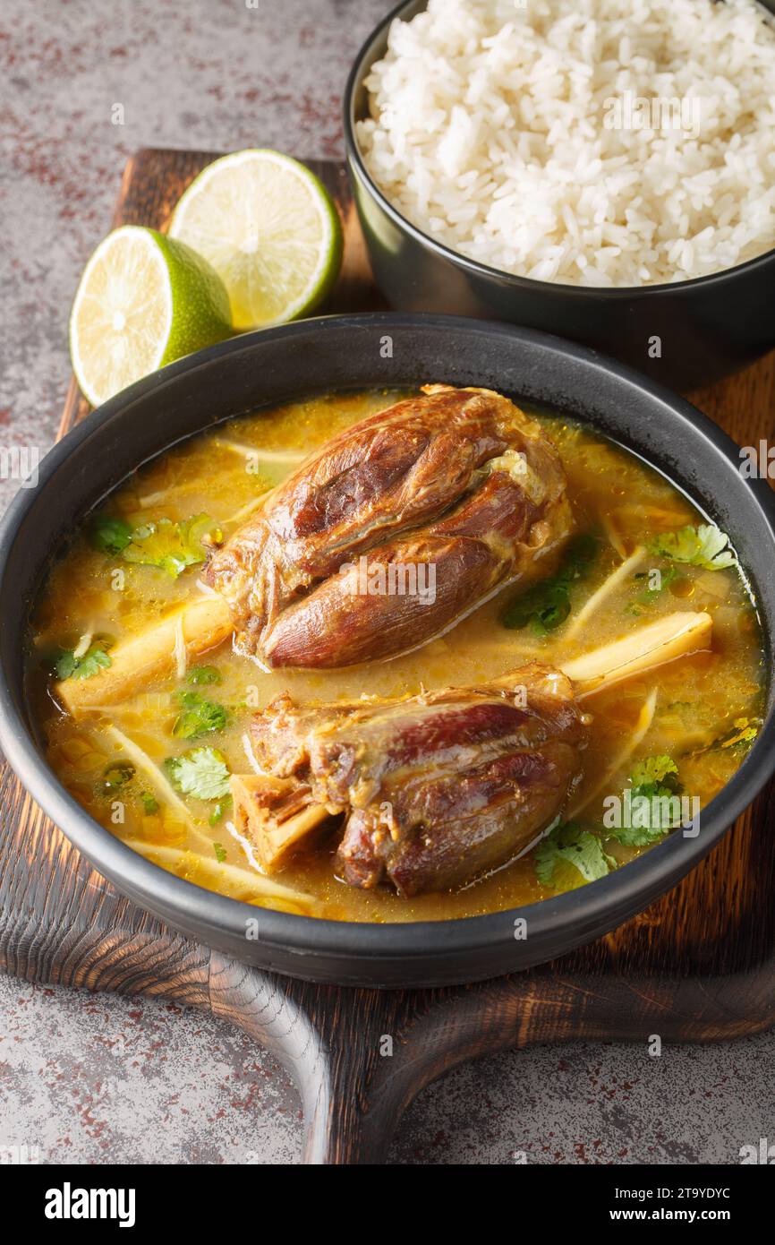Nihari is a rich slow-cooked meat stew flavored with spices and thickened with atta closeup on the wooden board on the table. Vertical Stock Photo