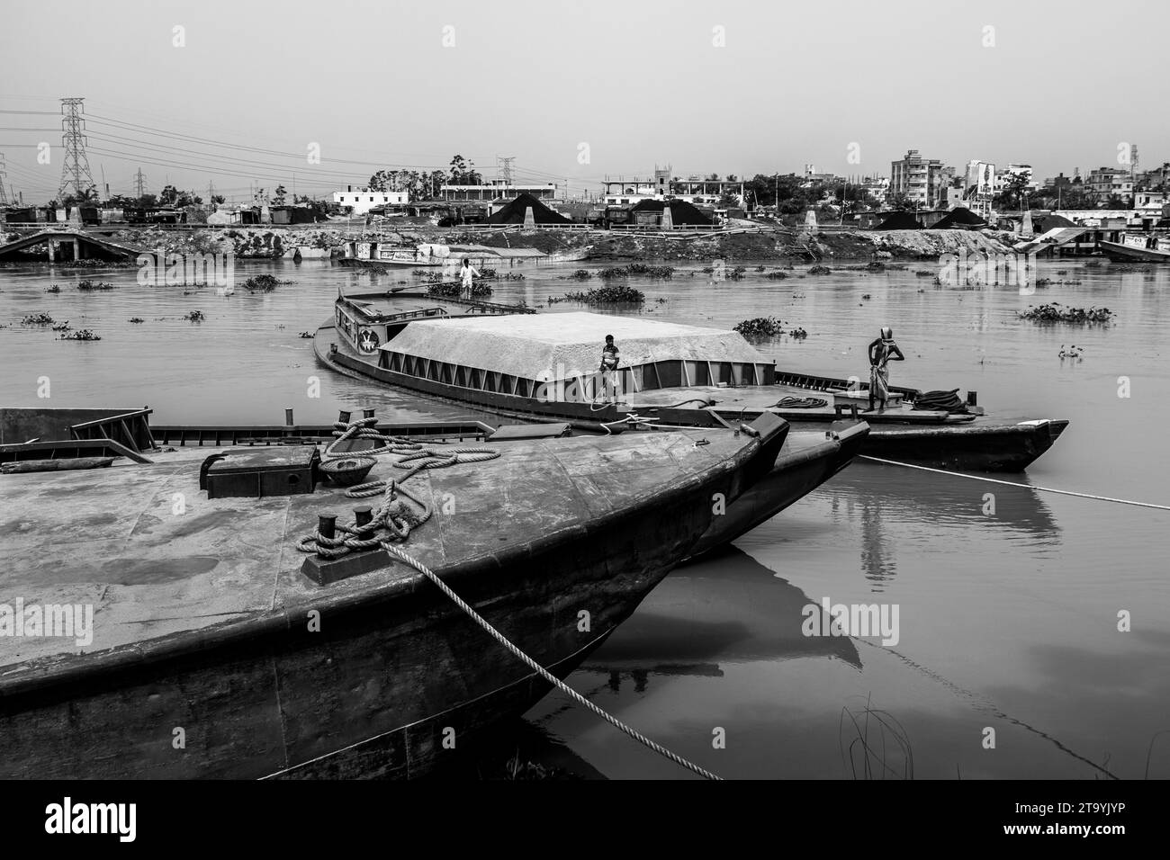 Traditional cargo boat station beside the riverbank. A picturesque scene unfolds along the riverbanks of Bangladesh as traditional cargo boats find th Stock Photo