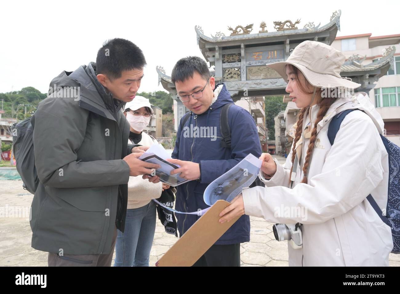 (231128) -- FUZHOU, Nov. 28, 2023 (Xinhua) -- Lin Yinan (1st, L) and his team check aerial photos of relics once built by foreigners in Fuzhou, southeast China's Fujian Province, Nov. 25, 2023. Kuliang, or Guling in Mandarin, is situated on the outskirts of Fuzhou, southeast China's Fujian Province. A century ago, foreigners residing in Fuzhou built villas in Kuliang, fostering a harmonious coexistence with local villagers and thus contributing to the enduring 'Kuliang stories.' 'The essence of the Kuliang stories lies in the connections between individuals. Although these foreigners had di Stock Photo