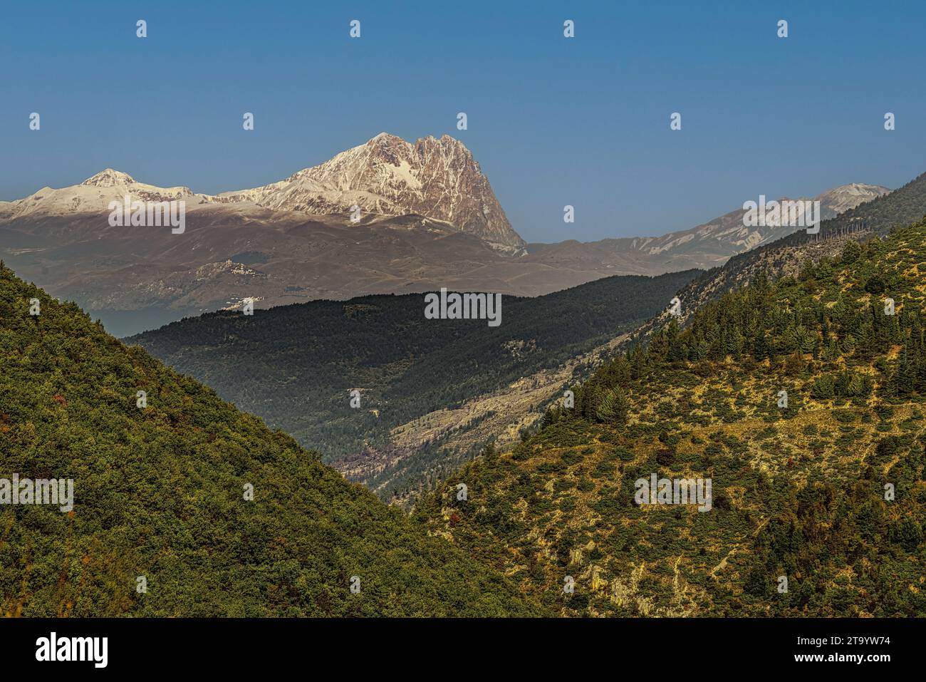 The Corno Grande, whitened by the first snow, dominates the mountains and woods still with their autumn colours. Abruzzo Stock Photo