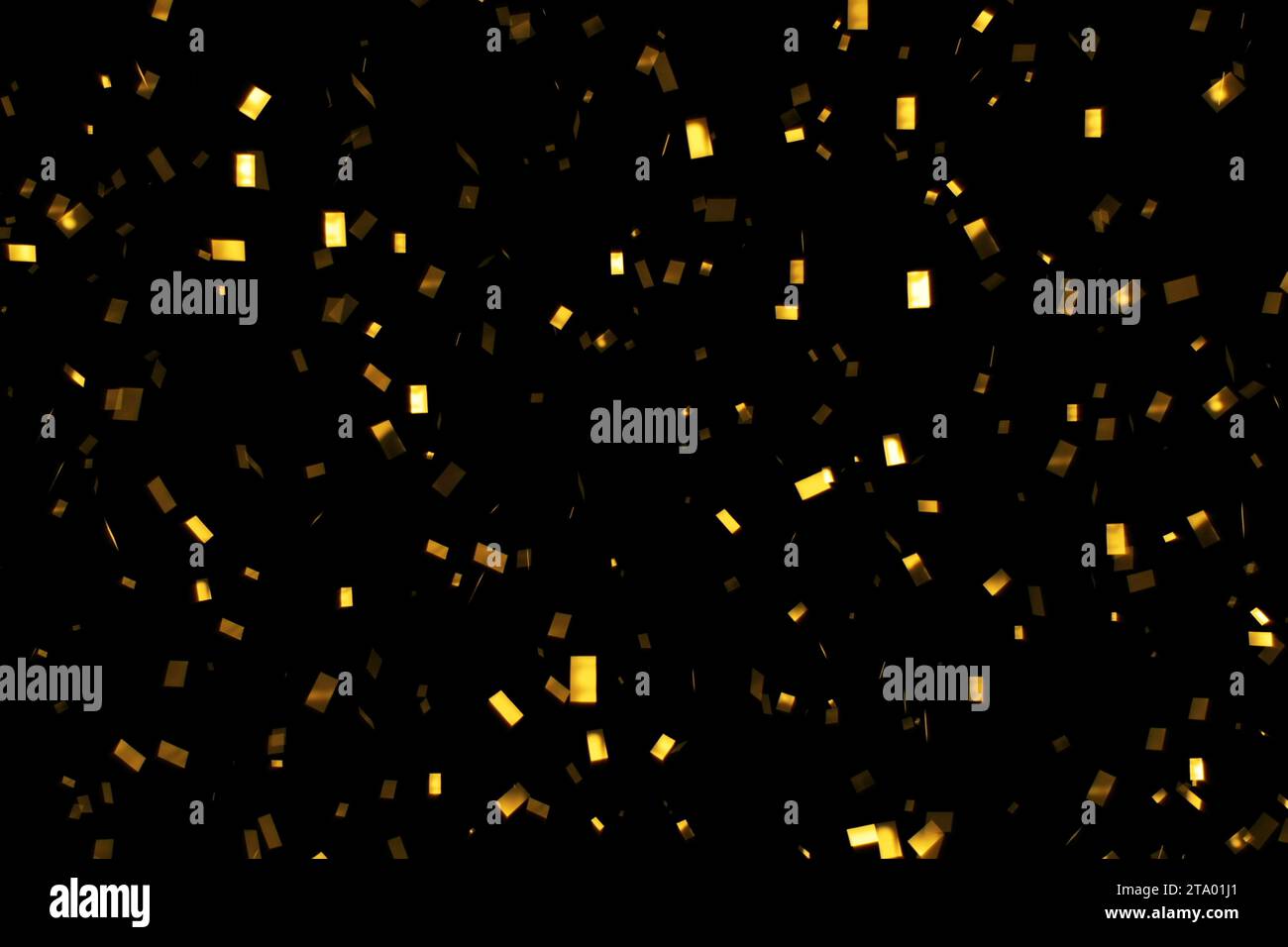 falling gold glitter foil confetti, on black background, holiday and ...
