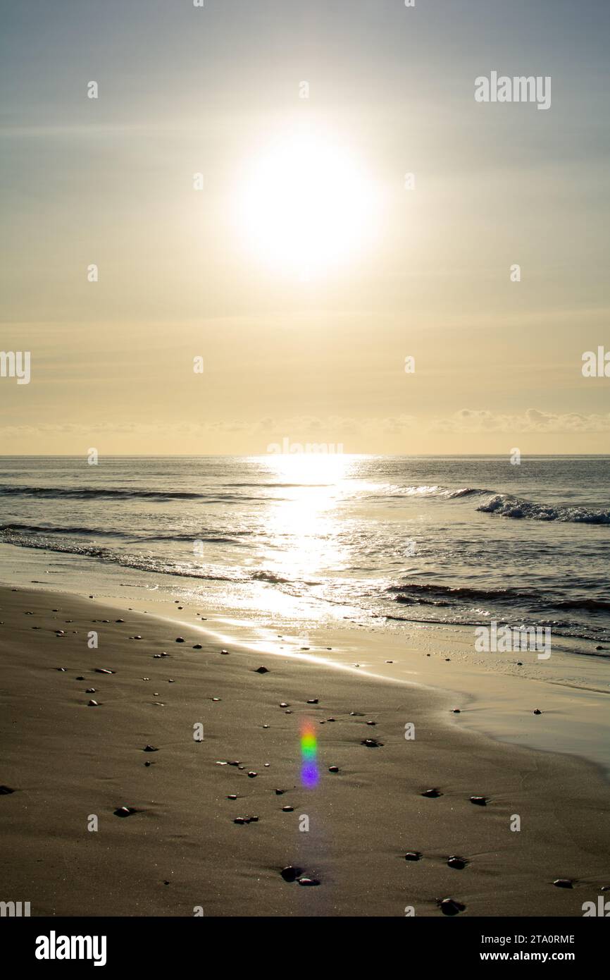 Sunrise on the sea around a sandy beach Stock Photo