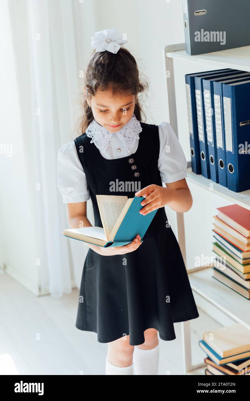 Schoolgirl girl reading a book at lesson Stock Photo - Alamy