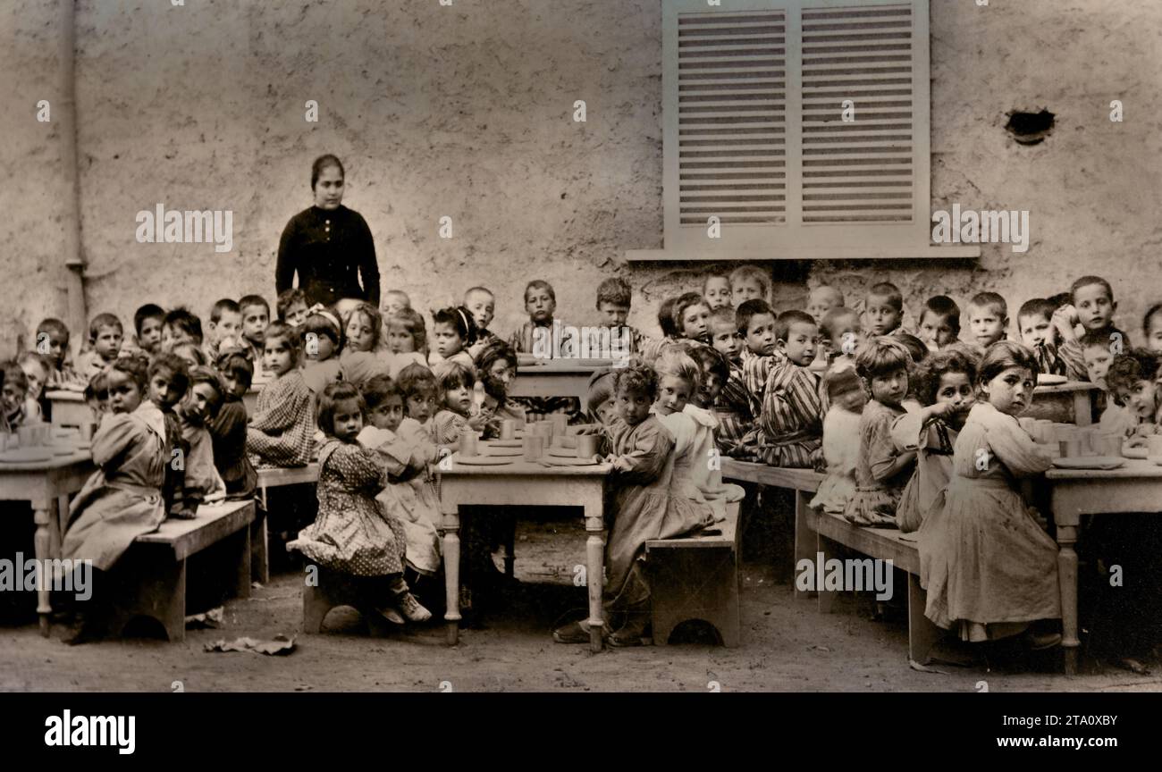 1900 Little girls and boys of the Pompeian Kindergartens having lunch on the premises of the school. Old Picture from the Orphanage for Children charity work has been done for orphans or support has been provided to orphans in some way. Cathedral of Pompeii - Sanctuary of Our Lady of the Rosary of Pompeii,   founded, 1876 - 1891, Italy, Italian, Stock Photo
