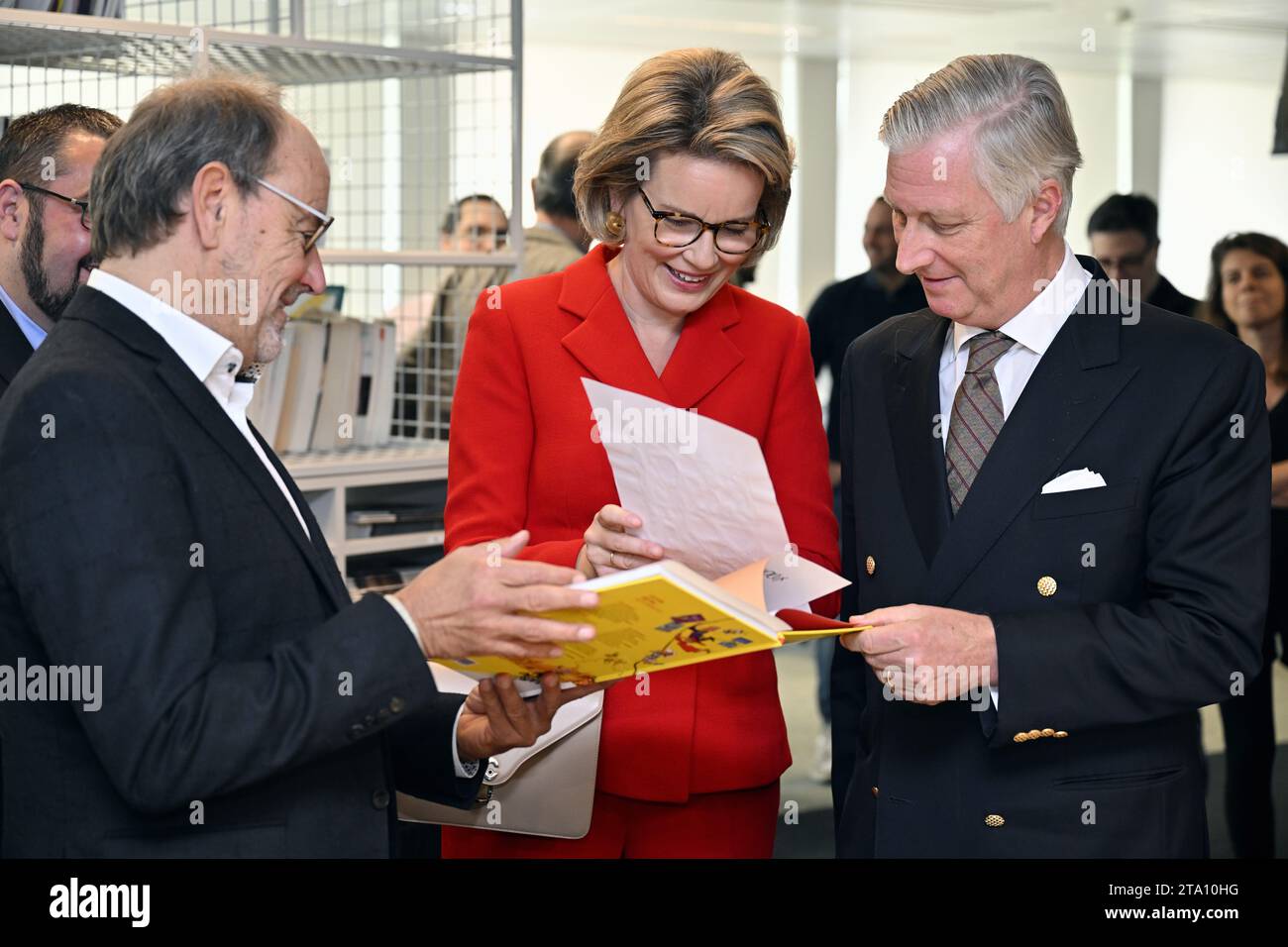 Cartoonist Pierre Kroll, Queen Mathilde of Belgium and King Philippe - Filip of Belgium pictured during a royal visit to the editorial floor of the newspaper Le Soir, in Brussels, Tuesday 28 November 2023. The royal couple will discover the technological and substantive innovations implemented within the editorial process, in particular the initiatives taken in terms of the digitalization of information, the transversal organization of editorial work, collaborative and investigative journalism. They meet the management and journalists of Le Soir throughout their visit. BELGA PHOTO ERIC LALMAN  Stock Photo