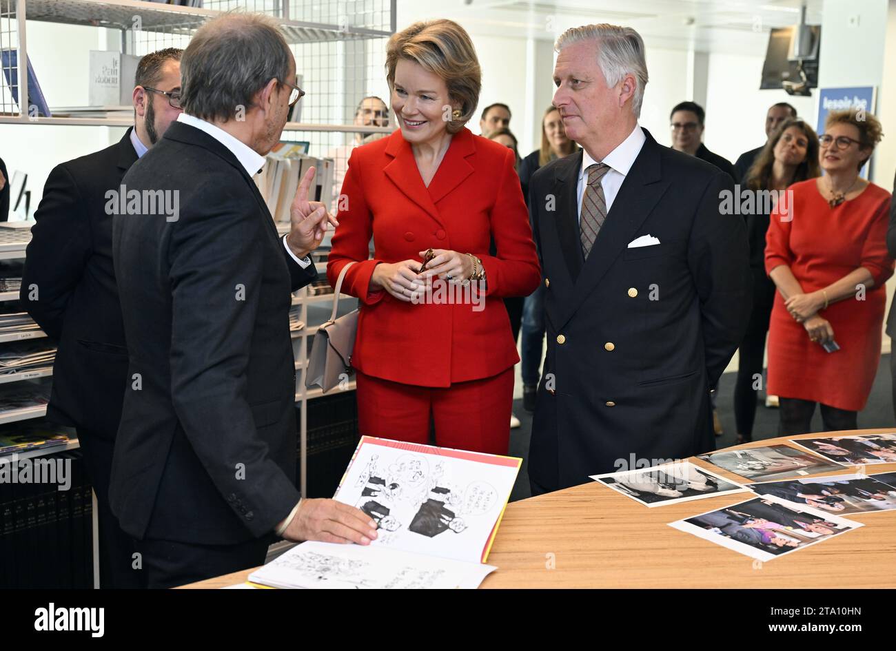 Cartoonist Pierre Kroll, Queen Mathilde of Belgium and King Philippe - Filip of Belgium pictured during a royal visit to the editorial floor of the newspaper Le Soir, in Brussels, Tuesday 28 November 2023. The royal couple will discover the technological and substantive innovations implemented within the editorial process, in particular the initiatives taken in terms of the digitalization of information, the transversal organization of editorial work, collaborative and investigative journalism. They meet the management and journalists of Le Soir throughout their visit. BELGA PHOTO ERIC LALMAN  Stock Photo