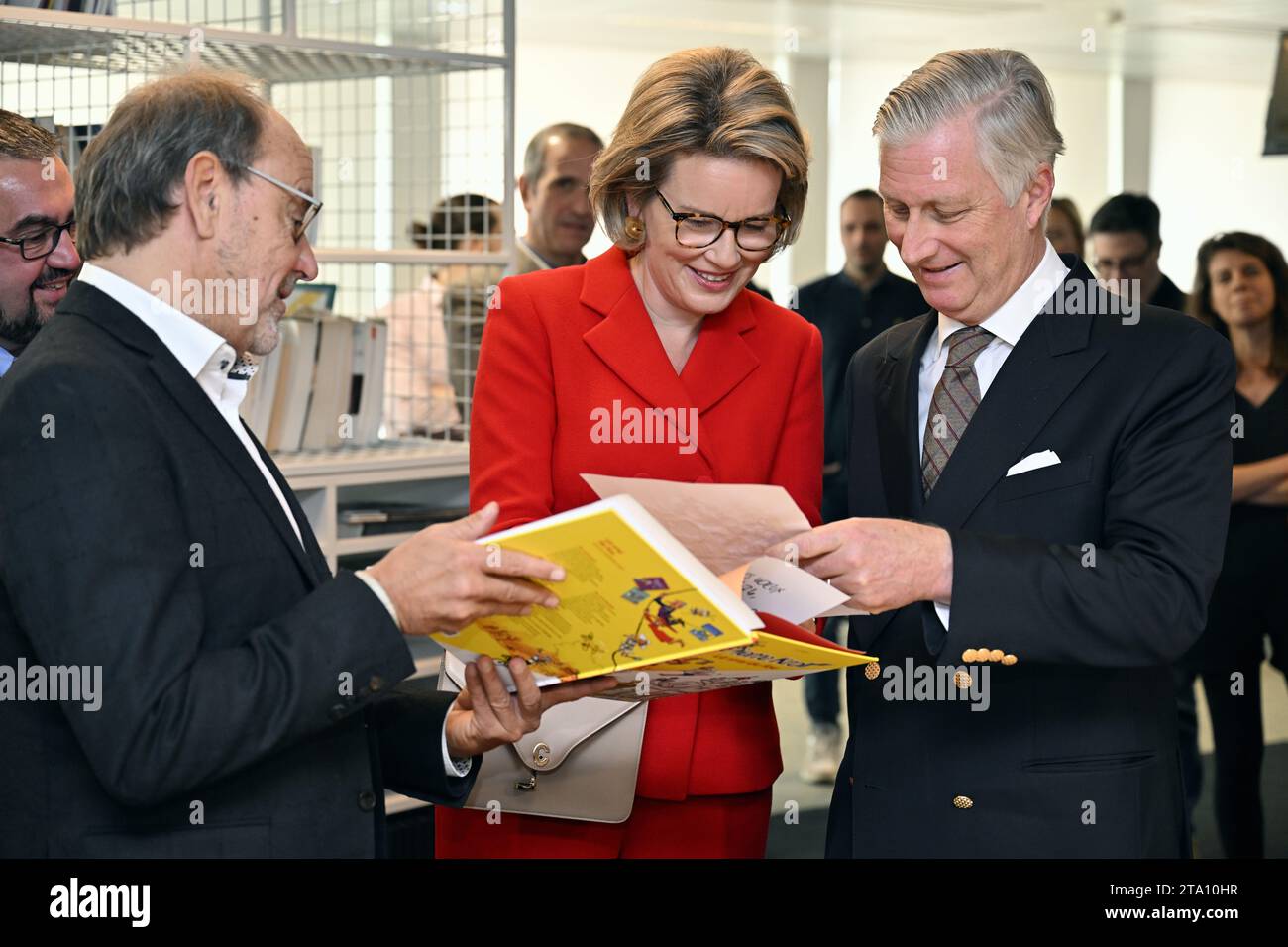 Cartoonist Pierre Kroll, Queen Mathilde of Belgium and King Philippe - Filip of Belgium pictured during a royal visit to the editorial floor of the newspaper Le Soir, in Brussels, Tuesday 28 November 2023. The royal couple will discover the technological and substantive innovations implemented within the editorial process, in particular the initiatives taken in terms of the digitalization of information, the transversal organization of editorial work, collaborative and investigative journalism. They meet the management and journalists of Le Soir throughout their visit. BELGA PHOTO ERIC LALMAN  Stock Photo