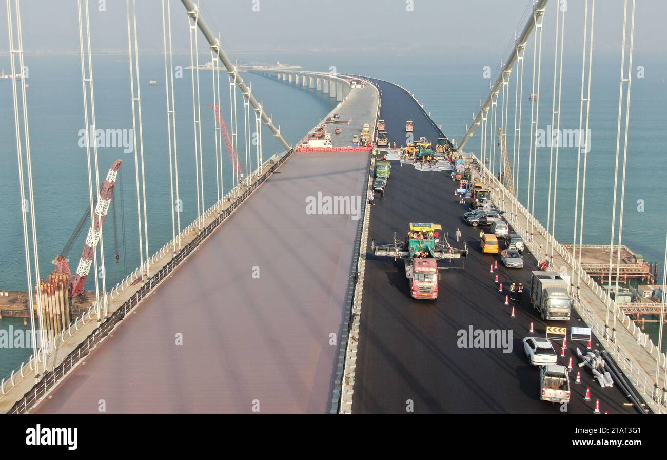 (231128) -- ZHONGSHAN, Nov. 28, 2023 (Xinhua) -- This aerial photo taken on Nov. 27, 2023 shows builders working on Lingdingyang bridge of the Shenzhen-Zhongshan link in south China's Guangdong Province. A cross-sea highway project between the cities of Shenzhen and Zhongshan in south China's Guangdong Province is one step closer to completion.   The last pouring of concrete was put in place on Tuesday, as work on the immersed tube underwater tunnel, which spans around 6.8 km, is nearing its end, said Guangdong Provincial Communication Group Co., Ltd.    The tunnel is part of a 24-km-long high Stock Photo
