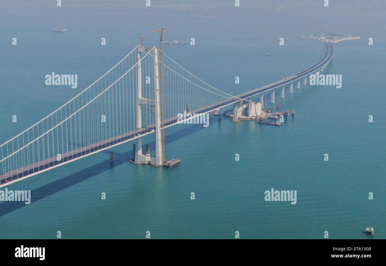 (231128) -- ZHONGSHAN, Nov. 28, 2023 (Xinhua) -- This aerial photo taken on Nov. 28, 2023 shows the east tower of Lingdingyang bridge and west artificial island of the Shenzhen-Zhongshan link in south China's Guangdong Province. A cross-sea highway project between the cities of Shenzhen and Zhongshan in south China's Guangdong Province is one step closer to completion.   The last pouring of concrete was put in place on Tuesday, as work on the immersed tube underwater tunnel, which spans around 6.8 km, is nearing its end, said Guangdong Provincial Communication Group Co., Ltd.    The tunnel is Stock Photo