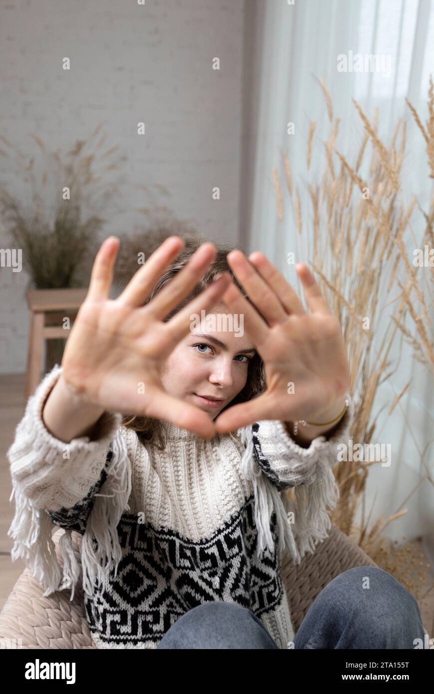 young pretty woman, teenager girl makes a frame gesture with her palms ...