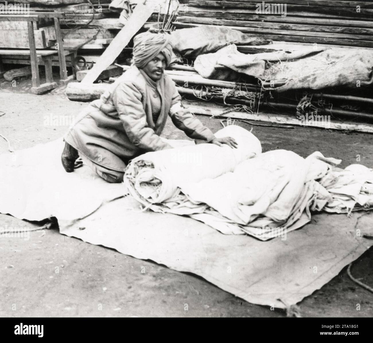 WW1 World War I - An Indian man rolls up bedding in an Indian hospital Stock Photo