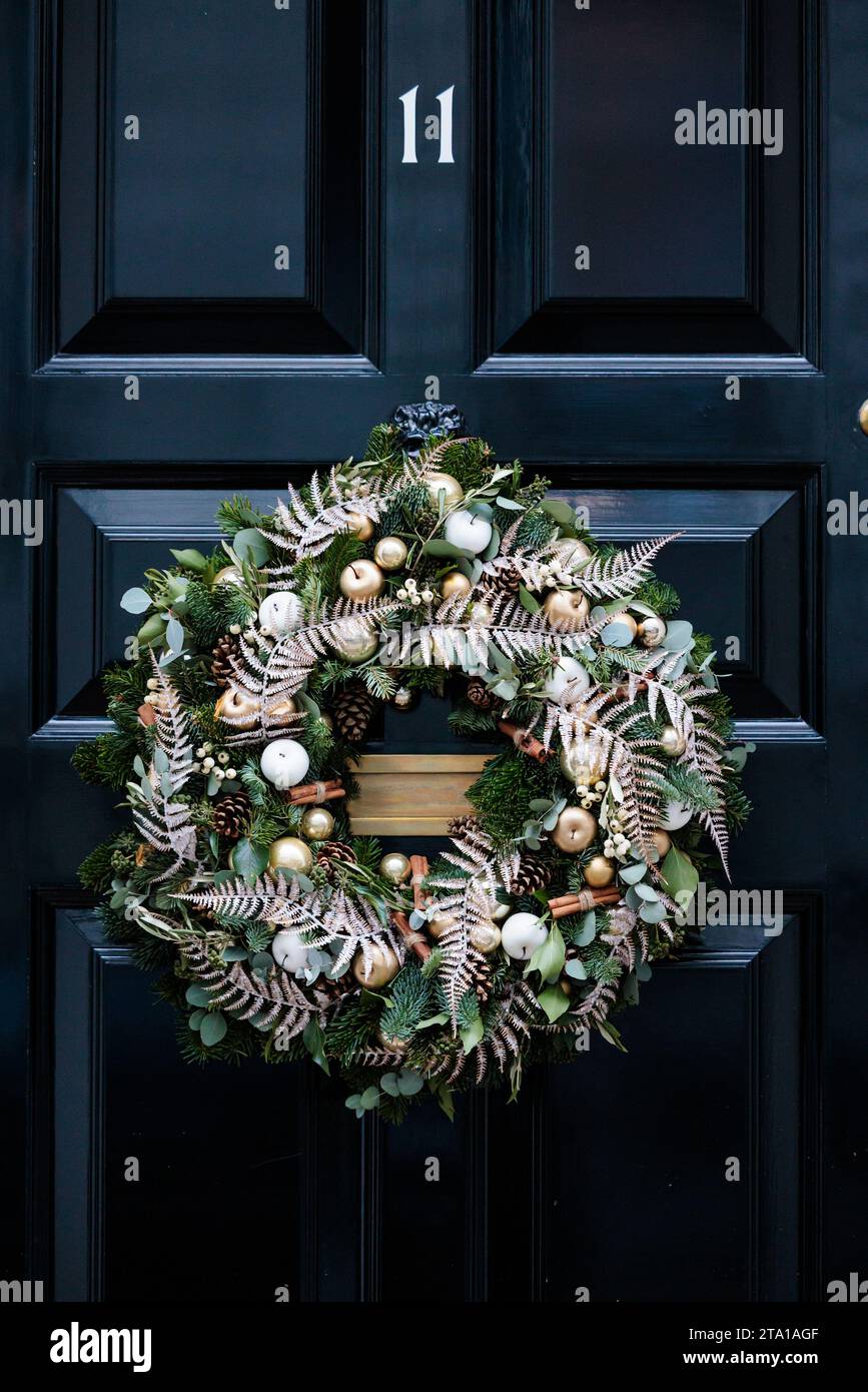Downing Street, London, UK. 28th November 2023.  Christmas Decorations in Downing Street. Festive wreath adorns the famous black door of No 11 Downing Street. Photo by Amanda Rose/Alamy Live News Stock Photo