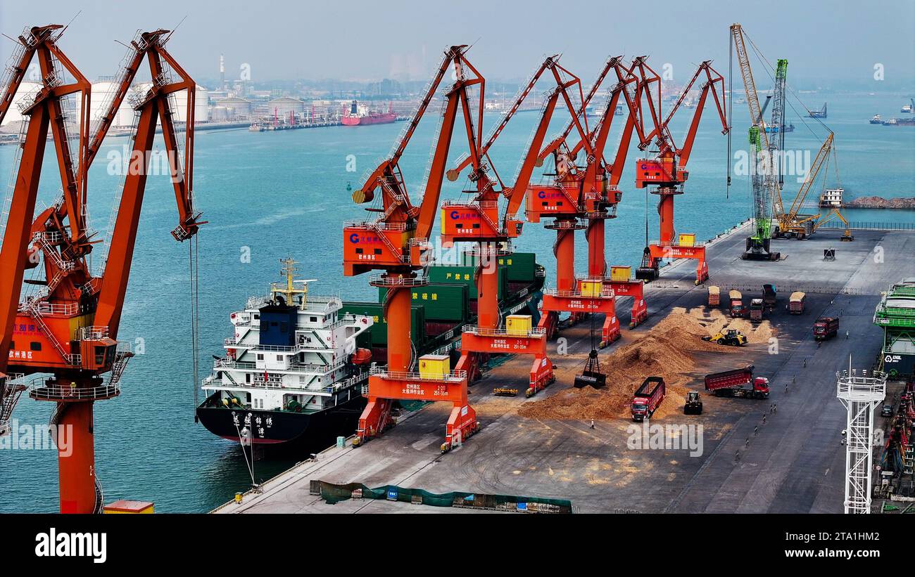 (231128) -- QINZHOU, Nov. 28, 2023 (Xinhua) -- This aerial photo taken on Nov. 24, 2023 shows a vessel unloading cargo at the Qinzhou Port in Qinzhou, south China's Guangxi Zhuang Autonomous Region.  Started as a small fishing village in 1992, the Qinzhou Port of south China's Guangxi has been constructed into a modern international pivotal hub along the New International Land-Sea Trade Corridor after 30 years of development. An automated container terminal for sea-rail intermodal services has been constructed in Qinzhou Port, along with the industrial cluster thriving at the Qinzhou Port sect Stock Photo