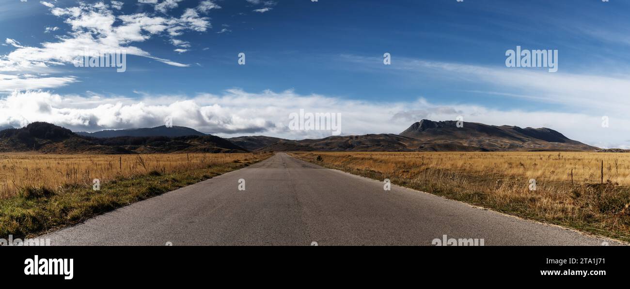 A country highway leading into the distance in the Gran Sasso and Monti della Laga National Park in the Apennine mountains of Italy Stock Photo