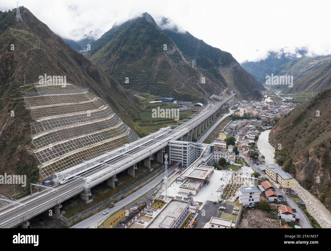 (231128) -- MAOXIAN, Nov. 28, 2023 (Xinhua) -- This aerial photo taken on Nov. 13, 2023 shows a high-speed passenger train making a stop at Zhenjiangguan railway station in southwest China's Sichuan Province. A 238-km section of the Sichuan-Qinghai railway in western China became operational on Tuesday after 12 years of construction.   The railway crosses the rugged, earthquake-prone plateau region in northwest Sichuan, and takes a detour to avoid disturbing the Giant Panda National Park.      The Sichuan-Qinghai railway will eventually stretch northwestward to Xining, the capital city of Qing Stock Photo