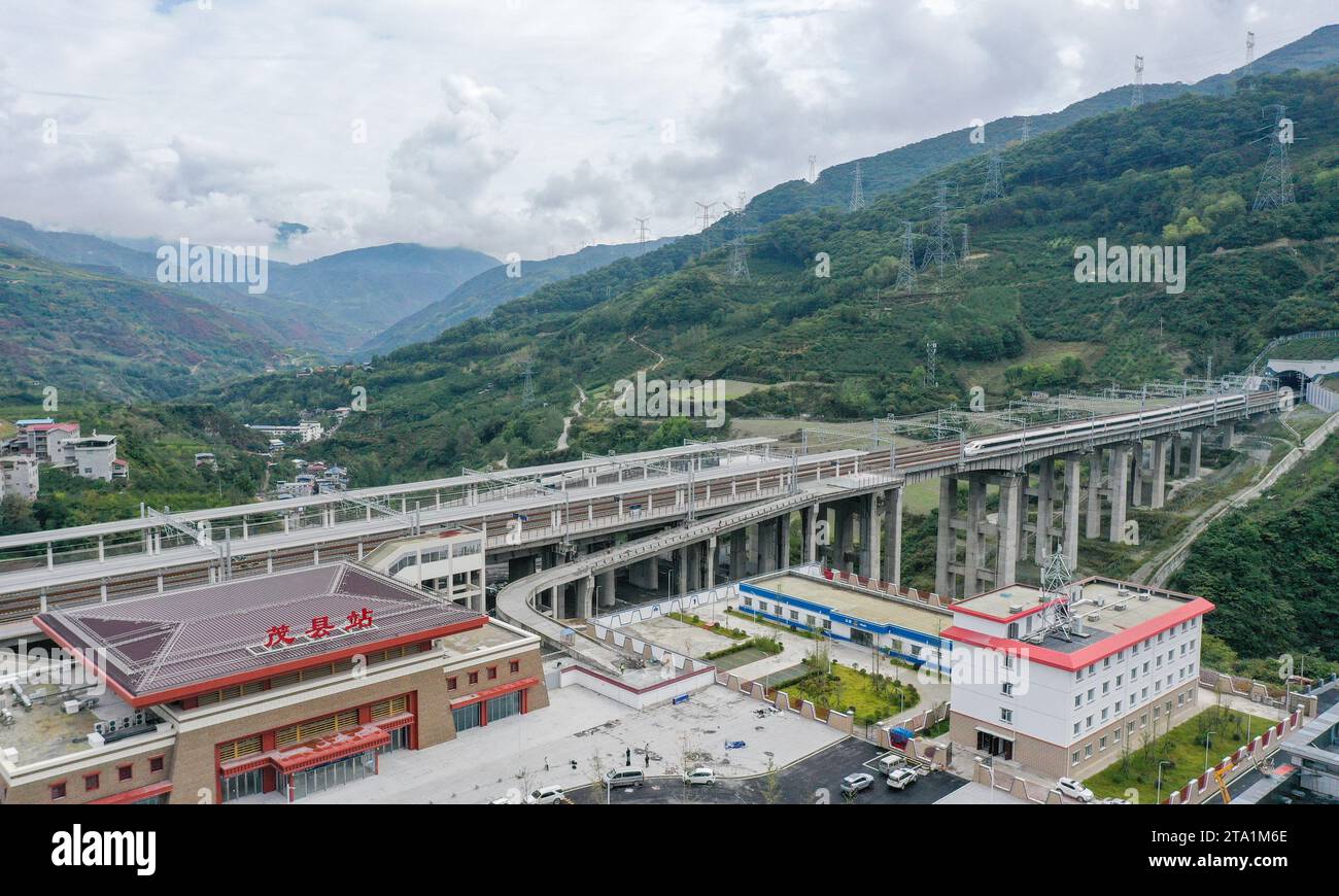 (231128) -- MAOXIAN, Nov. 28, 2023 (Xinhua) -- This aerial photo taken on Oct. 13, 2023 shows a train for commissioning and testing arriving at Maoxian railway station in Maoxian County, southwest China's Sichuan Province. A 238-km section of the Sichuan-Qinghai railway in western China became operational on Tuesday after 12 years of construction.   The railway crosses the rugged, earthquake-prone plateau region in northwest Sichuan, and takes a detour to avoid disturbing the Giant Panda National Park.      The Sichuan-Qinghai railway will eventually stretch northwestward to Xining, the capita Stock Photo