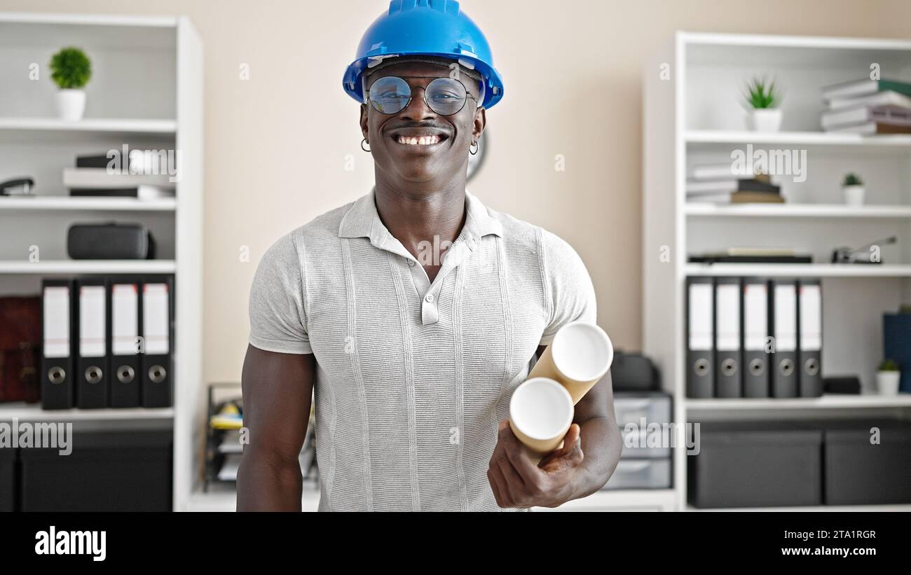 African american man architect smiling confident holding blueprints at the office Stock Photo