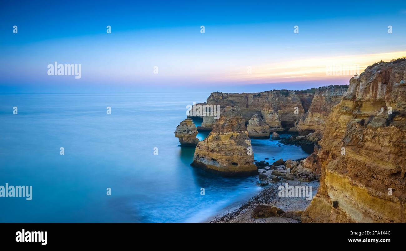 Limestone cliffs at Praia Da Marinha beach at dusk in the Algarve region of southern Portugal Stock Photo