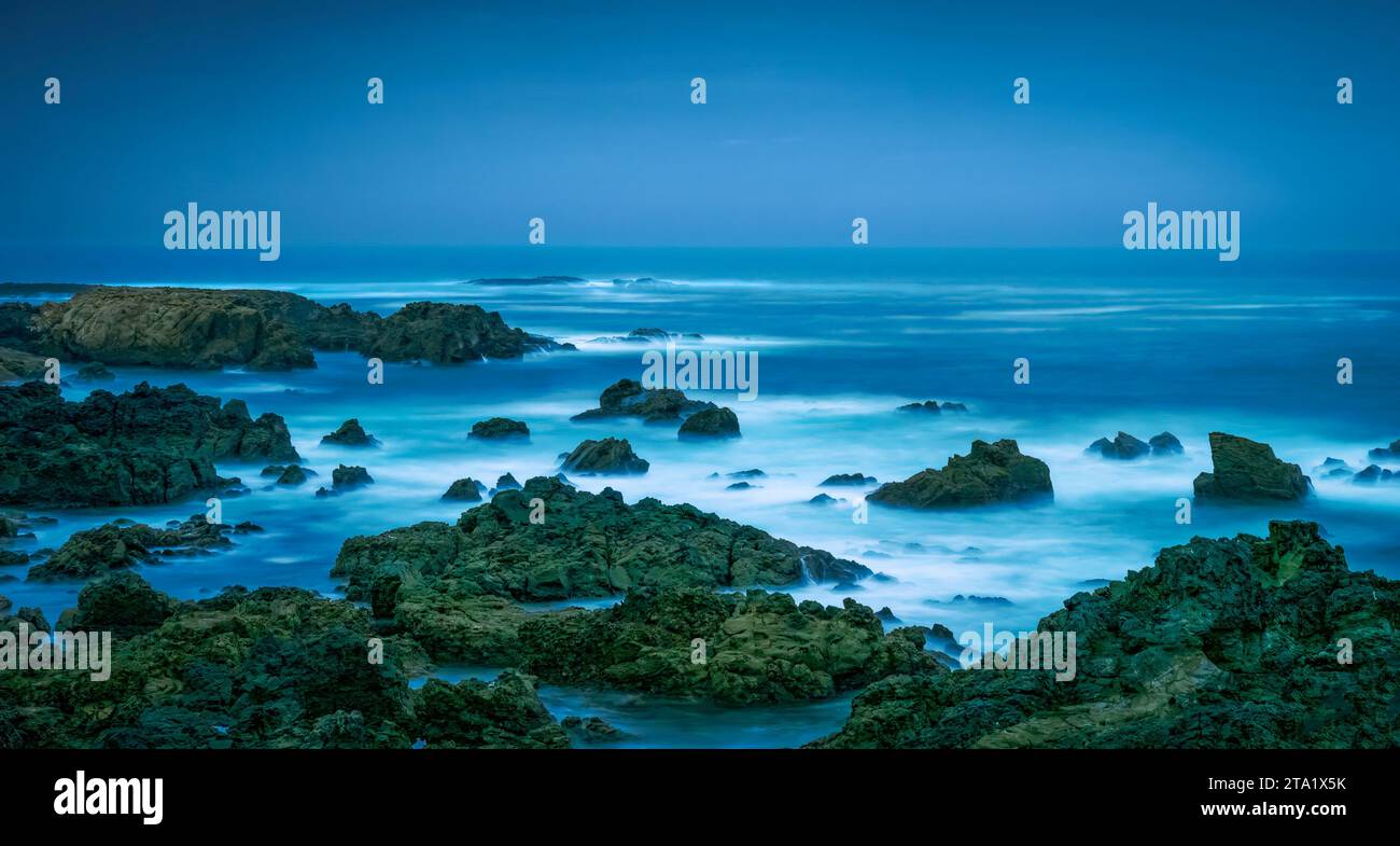Dusk along the rocky shoreline of the Atlantic Ocean in the Costa Azul region of Portugal Stock Photo